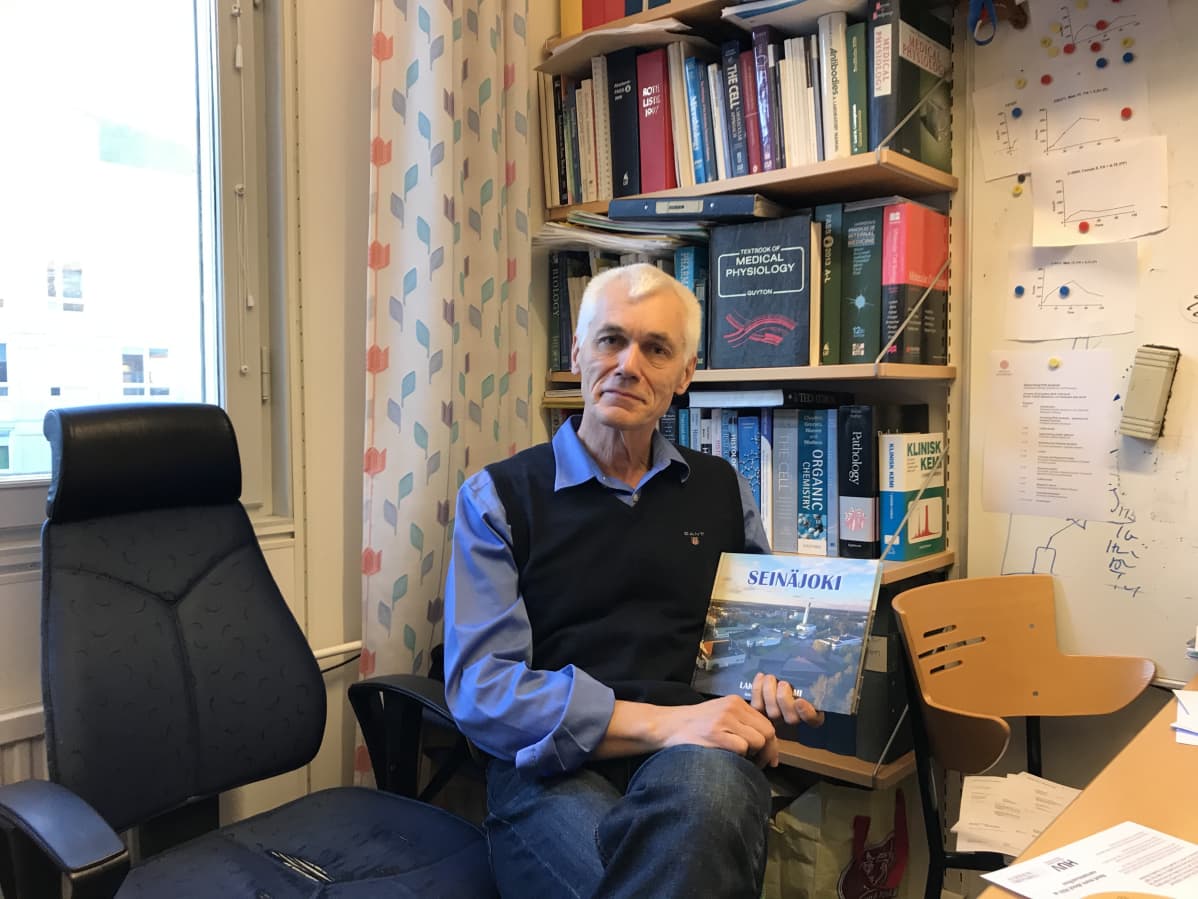 Uppsalan yliopiston tutkjia Peter Bergsten pitää Seinäjoesta kertovaa kirjaa kädessään.