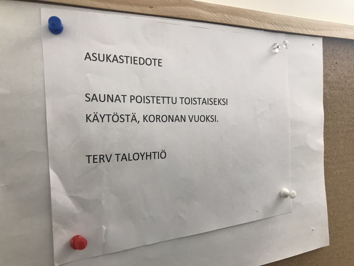 Taloyhtiön lappu saunojen sulkemisesta ilmoitustaululla.
