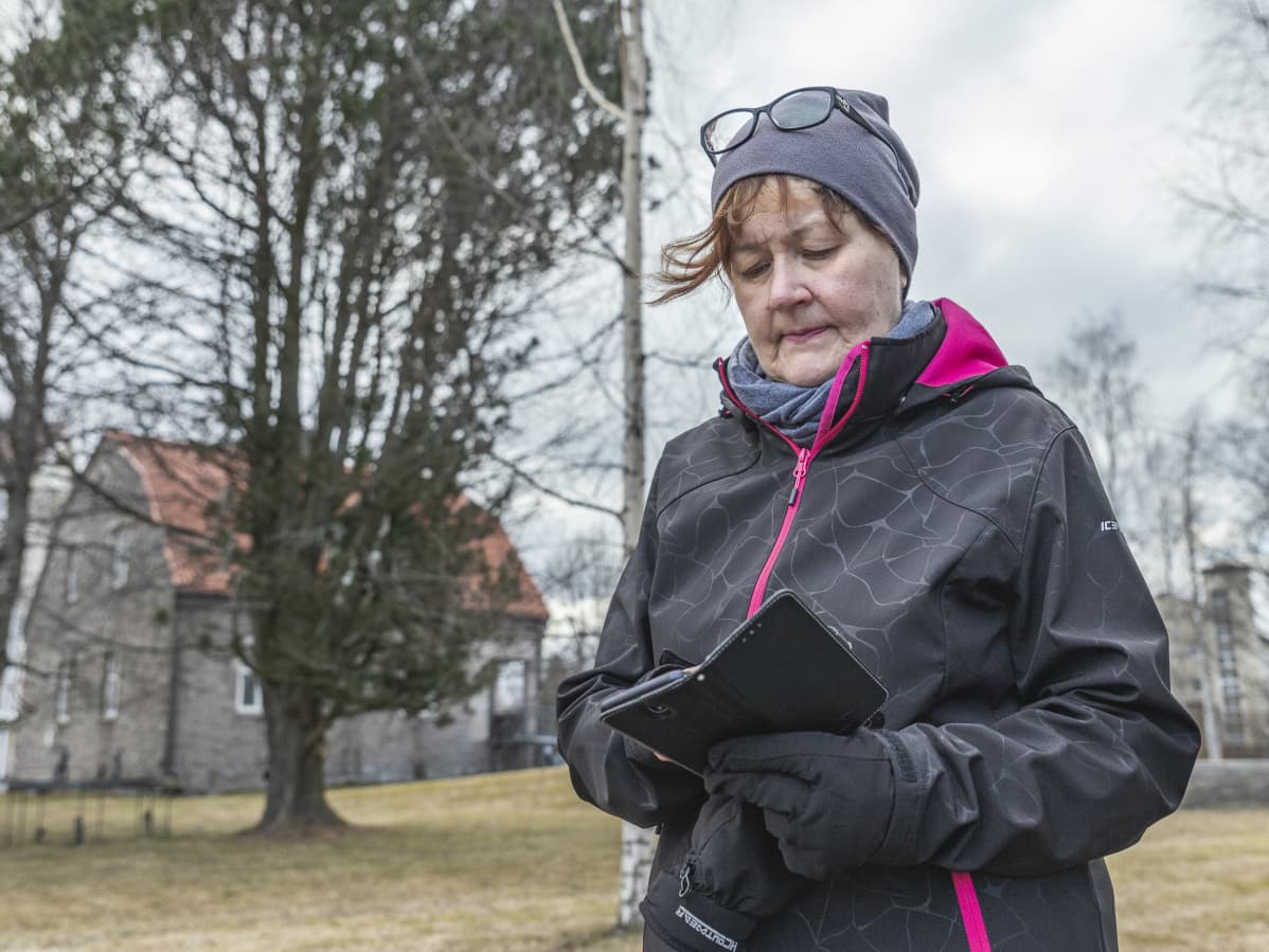 Riitta näppäilee puhelinta.