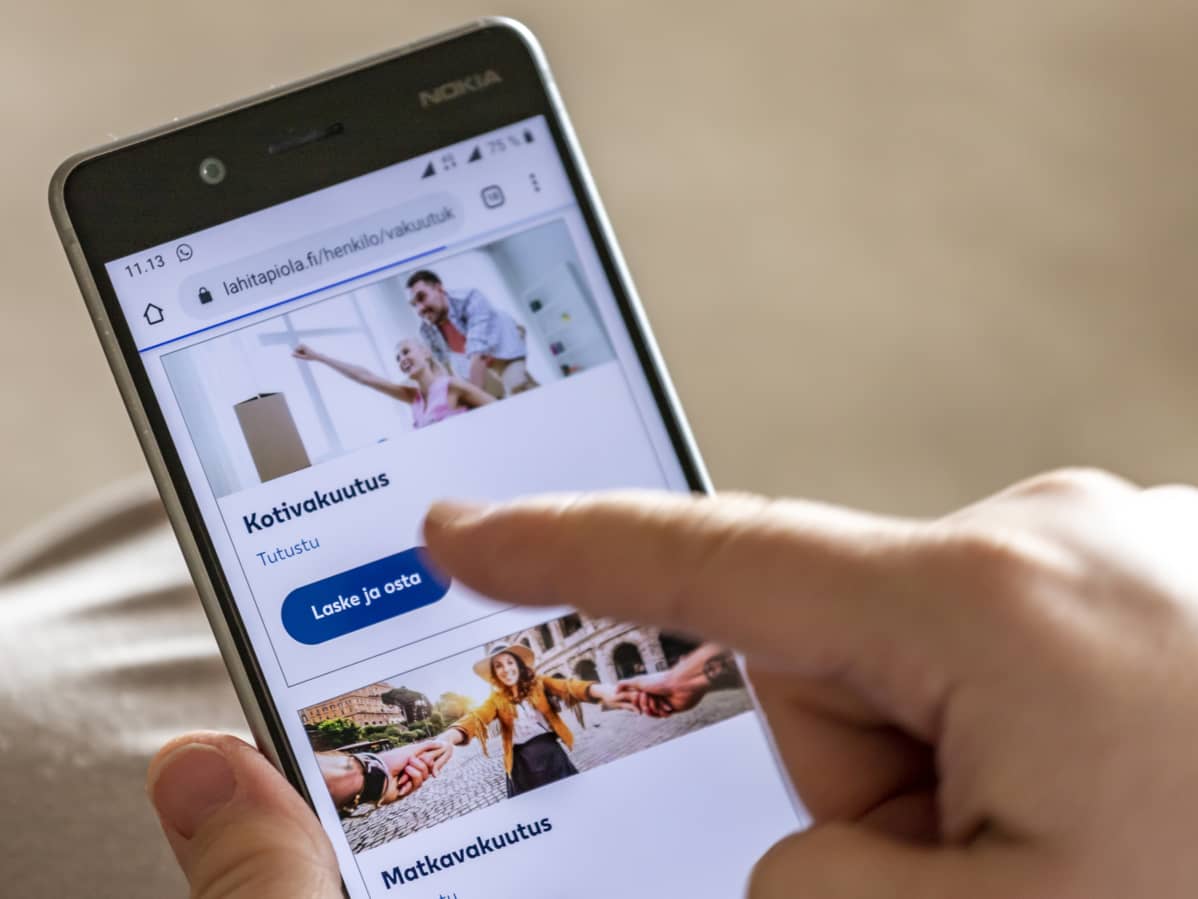 Henkilö selaa matkapuhelimella vakuutusyhtiön nettisivuja.