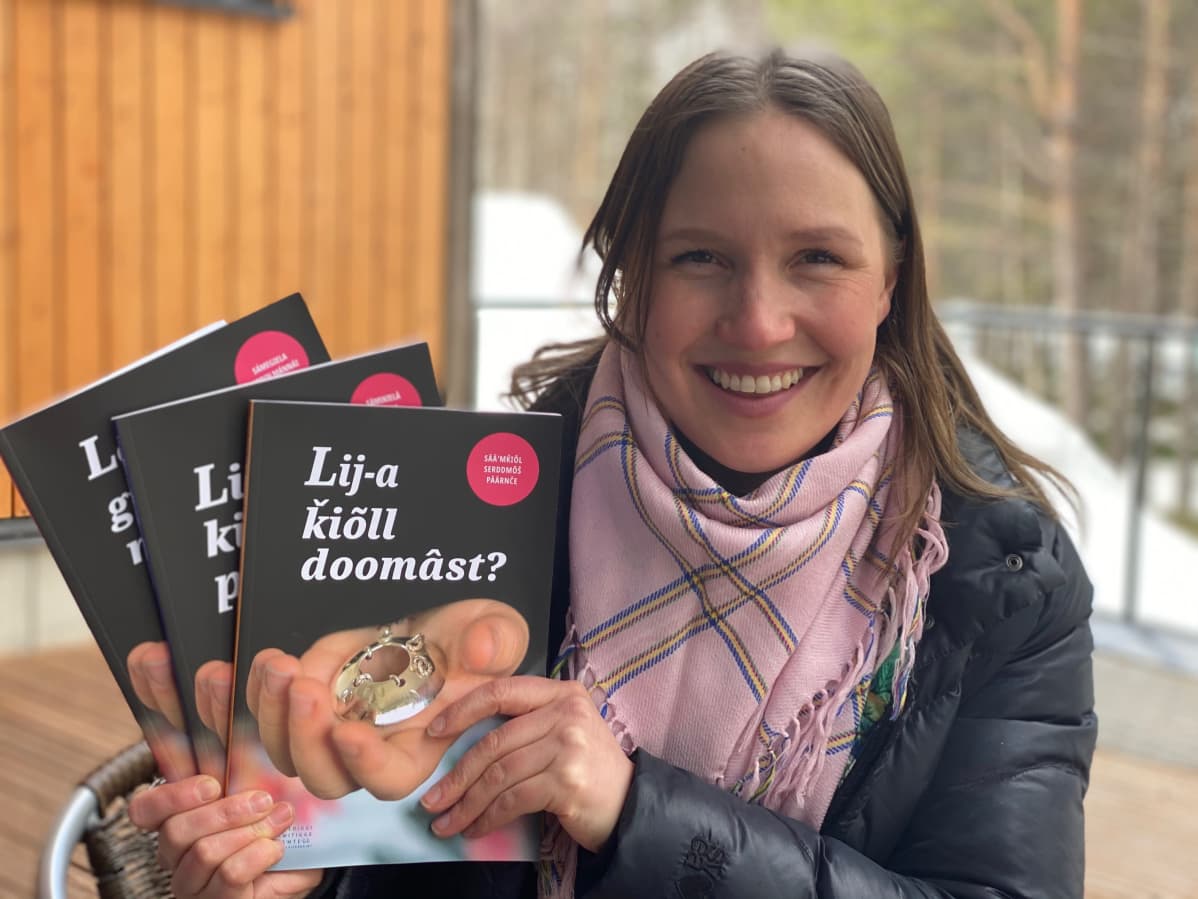Kieliturvasihteeri Anne Kirste Aikio esittelee vanhemmille jaettavaa opasta kielen siirtämiseen.