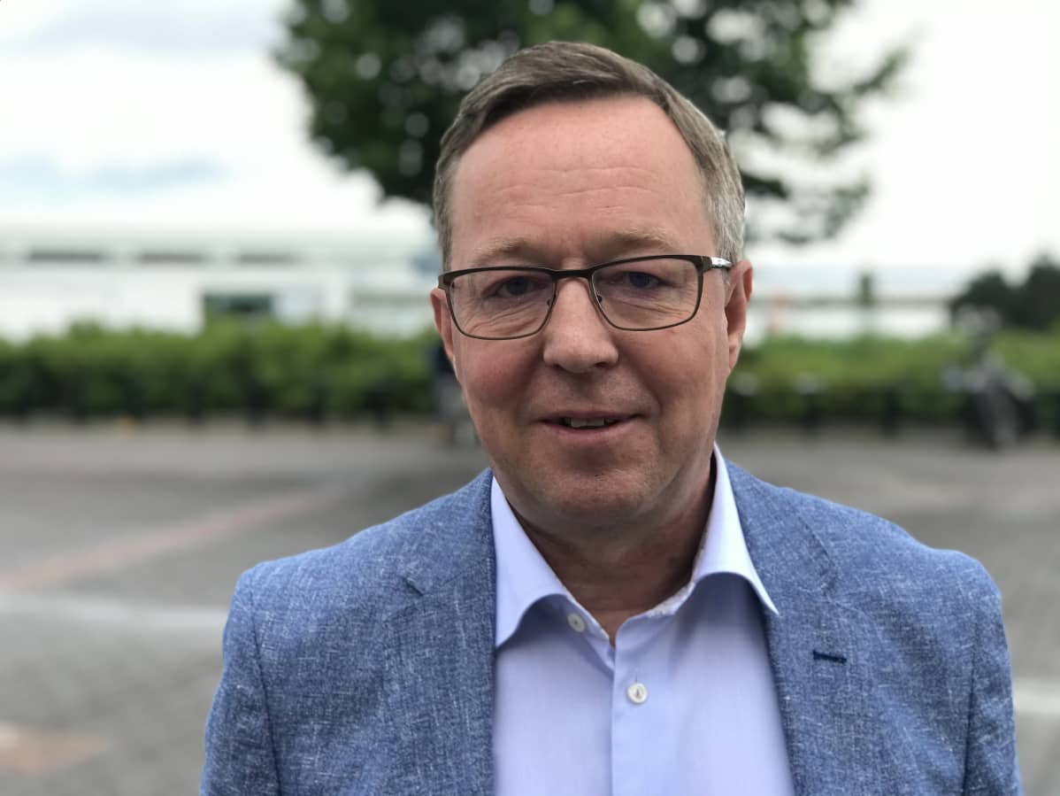 Mika Lintilä katsoo kameraan, lähikuva, sininen pikkutakki päällä