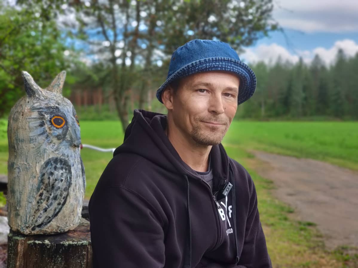 Maanviljelijä Juha Rautiainen istuu kotipihansa portilla