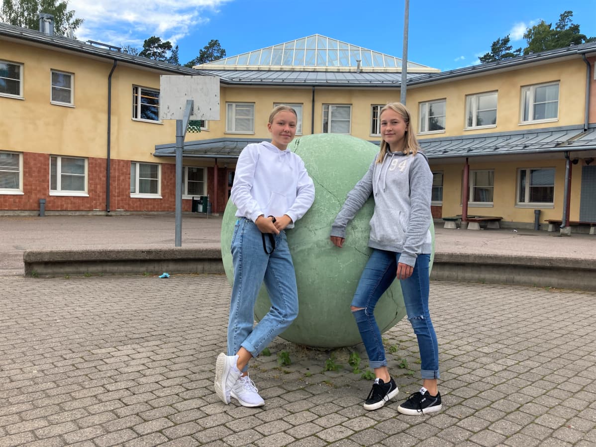 Kuvassa Aava Tammilehto ja Aino Kaariskorpi Merilahden peruskoulun pihalla.