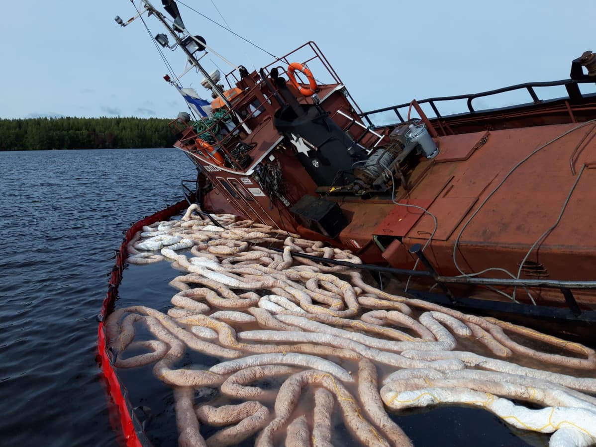 Hinaaja ja öljyntorjuntapuomit vedessä