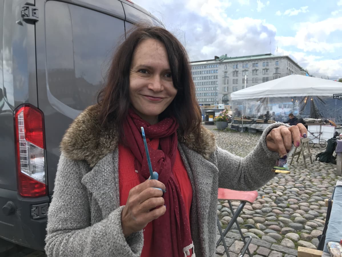 Arina Lebedeva, myyjä torilla, maalaa itse kelloja.