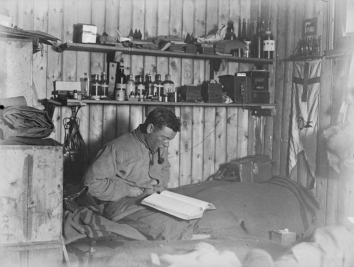 George Murray Levick lukemassa sängyllään retkikunnan käyttämässä tukikohdassa Etelämantereella 1910-luvulla.