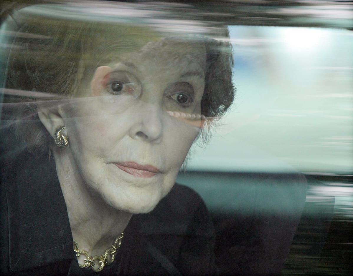 Nancy Reagan katsoo ylos auton ikkunasta.