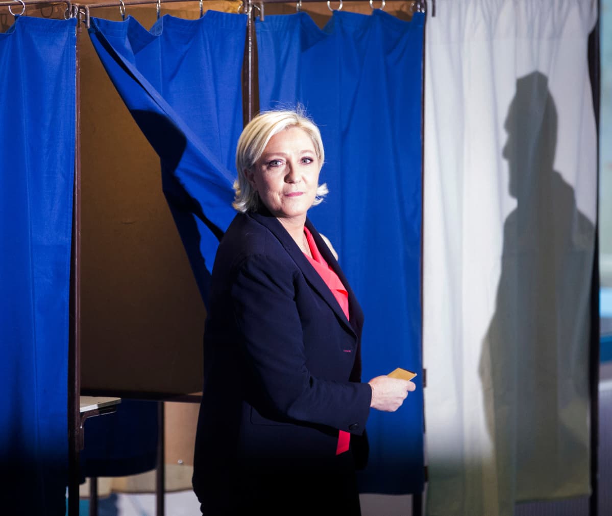Marine Le Pen tulee verhon takaa äänestyskopista.