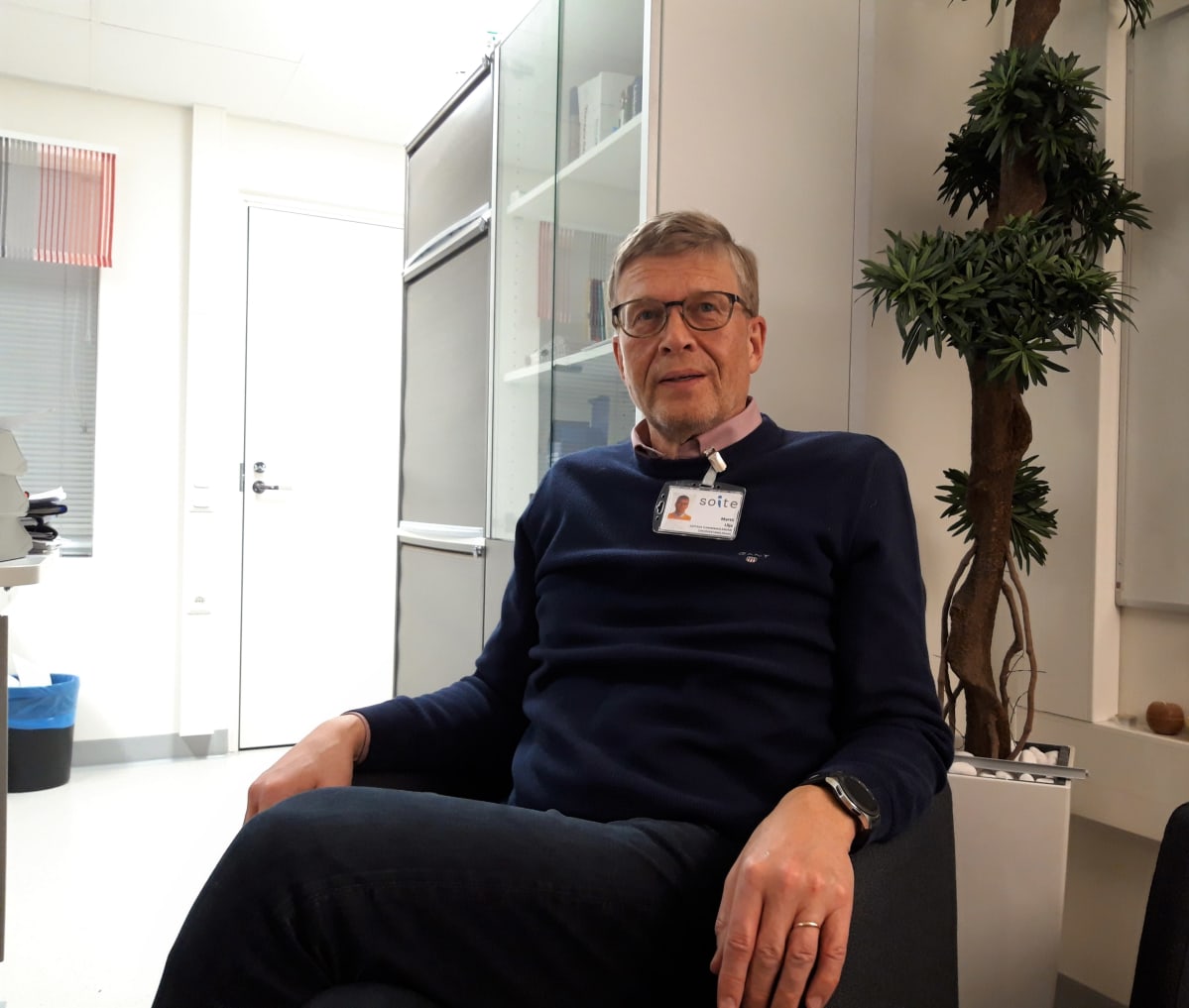 Mies istuu työtuolissaan.