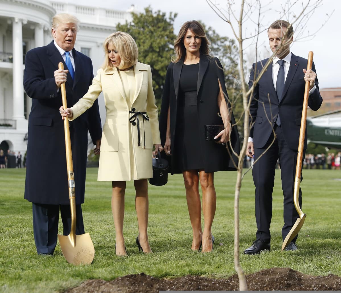 Yhdysvaltain presidentti Donald Trump, Ranskan presidentti Emmanuel Macron sekä puolisot Melania Trump ja Brigitte Macron istuttavat puita Valkoisen talon pihalla.