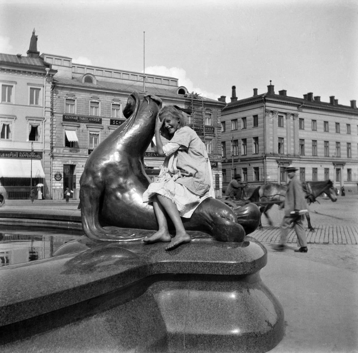Tyttö merileijonan selässä Havis Amandan suihkulähteellä.
