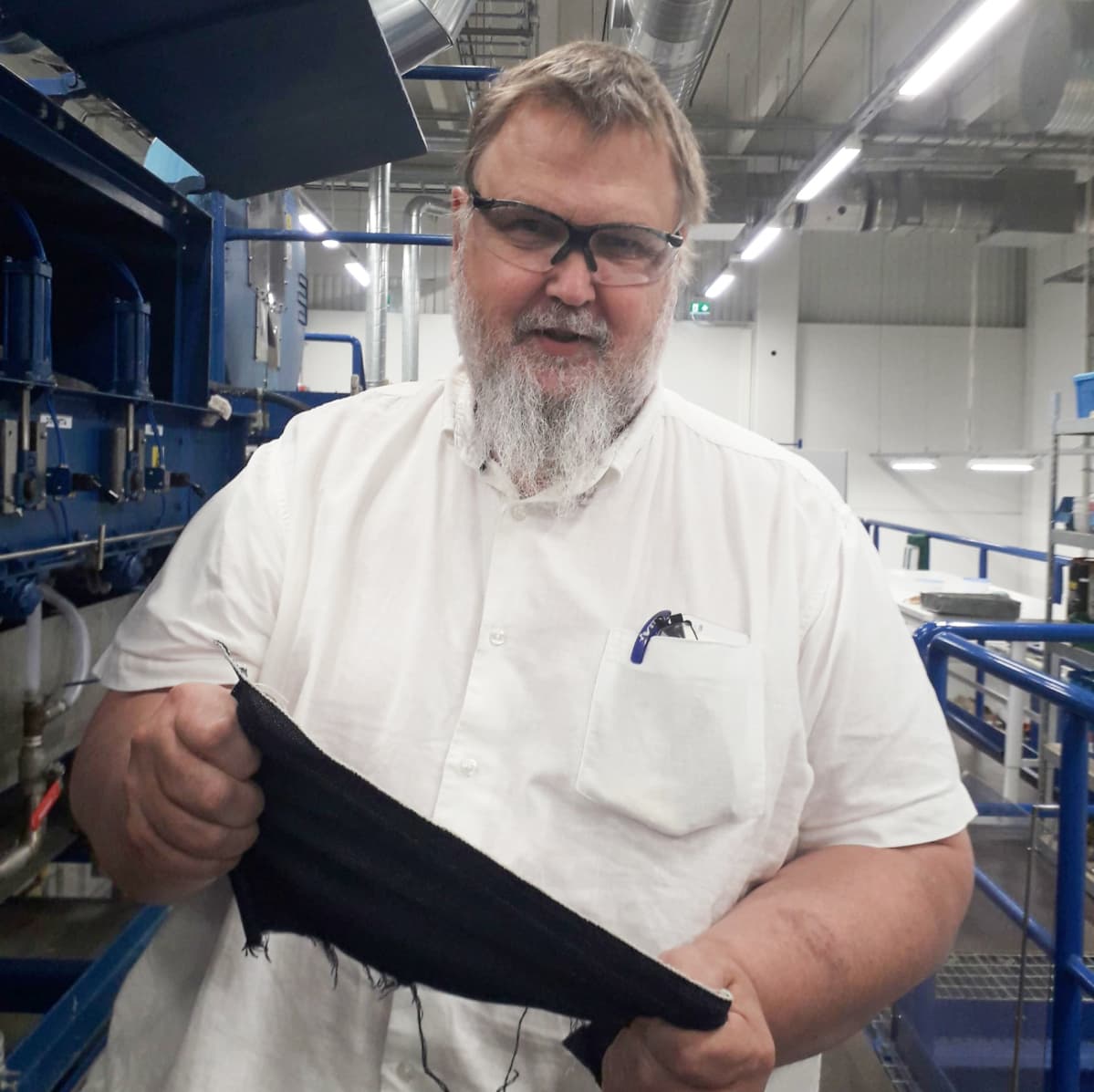 Teknologian kehittämiskeskus VTT:n tutkimusprofessori Ali Harlin esittelee kierrätetystä kuidusta valmistettua farkkukangasta.
