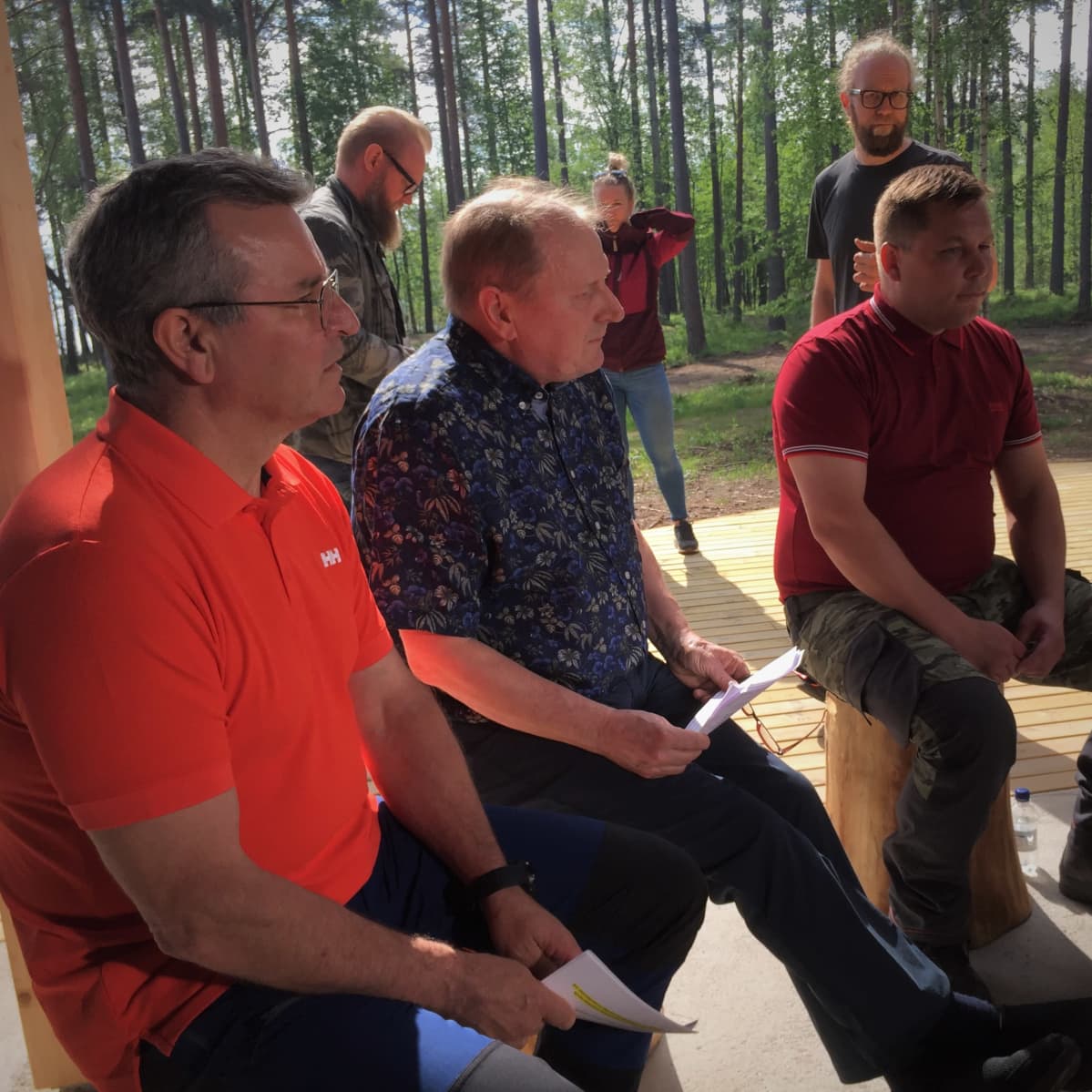 Taipalsaaren kunnan johtomiehet istuvat retkeilykatoksen alla Sarviniemessä.