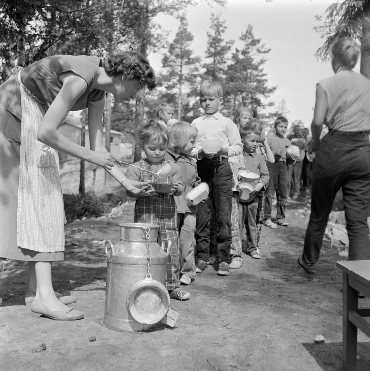 1950-luku, lapsia jonottamassa ruokaa leikkipuistossa.
