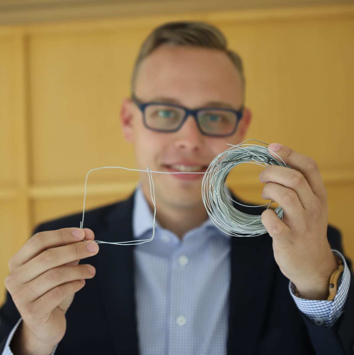Matias Marttinen pitää edessään neliöksi taiteltua rautalankaa