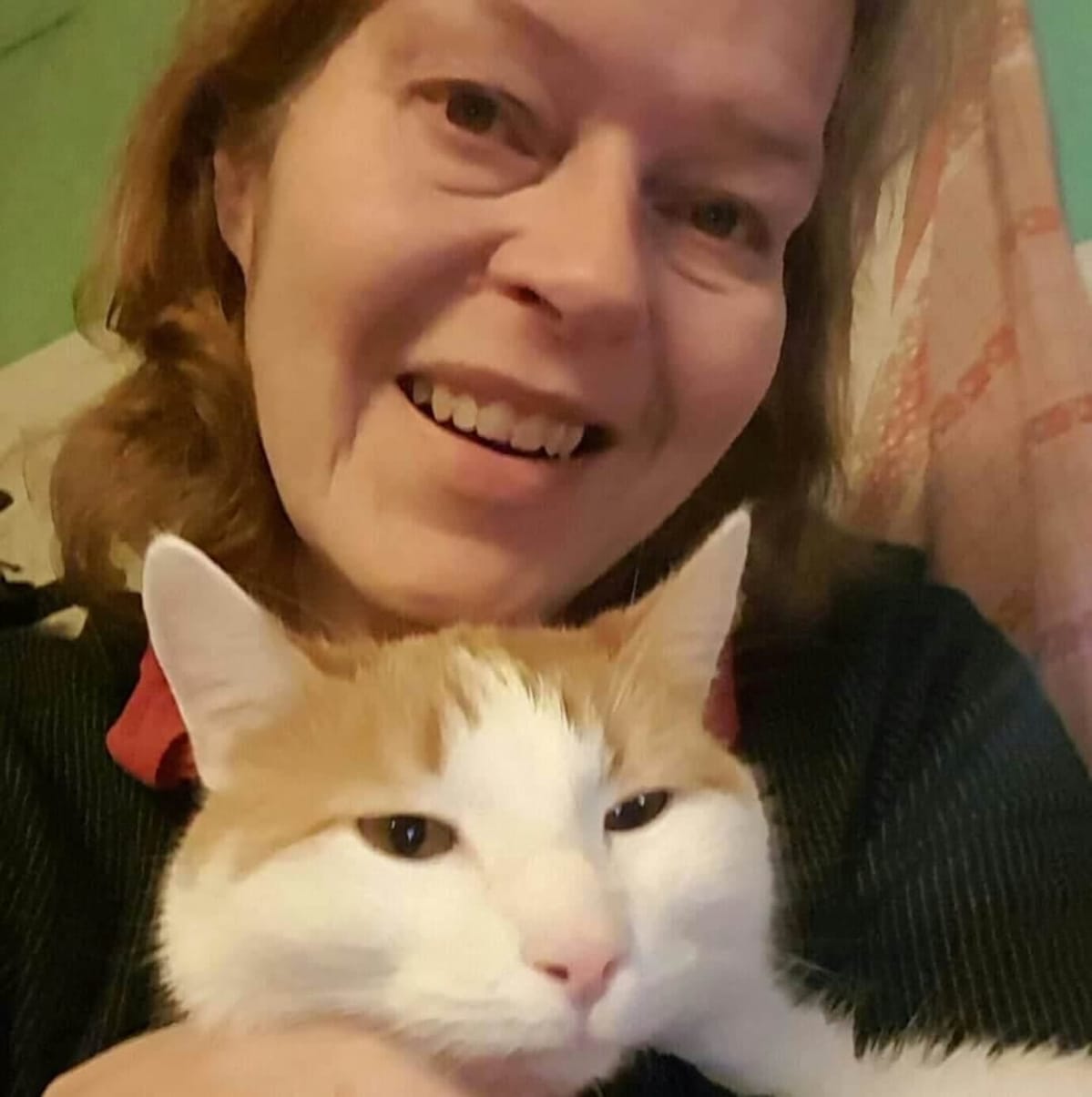 Tiina Autonen poseeraa perheen kissan kanssa.