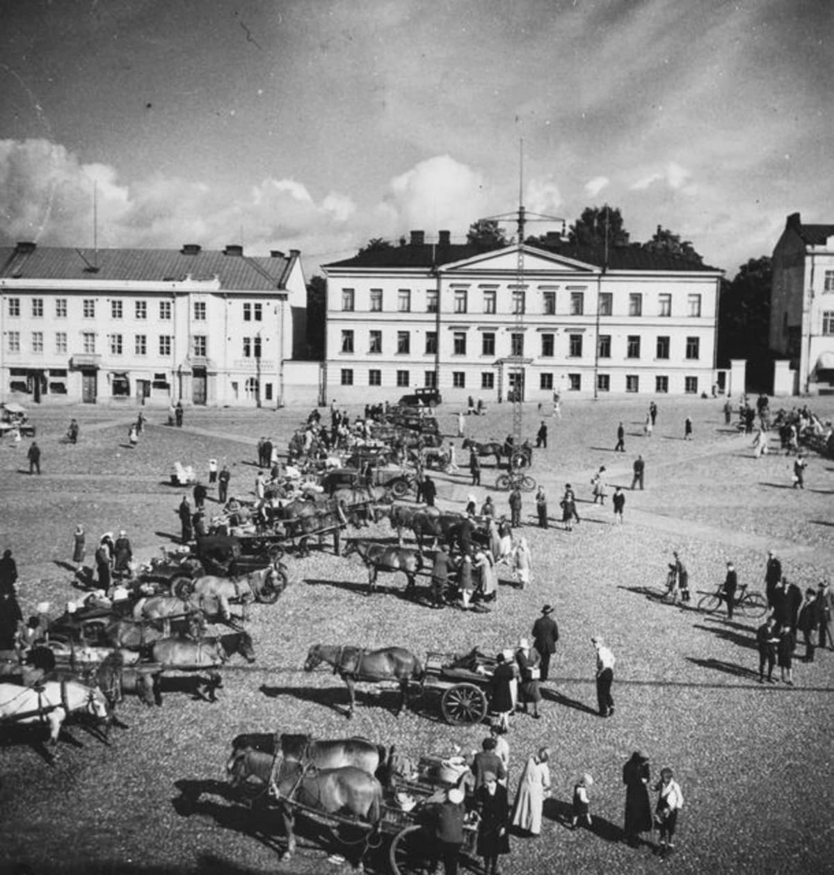 Hämeenlinnan torilla ihmisiä ja hevoskärryjä