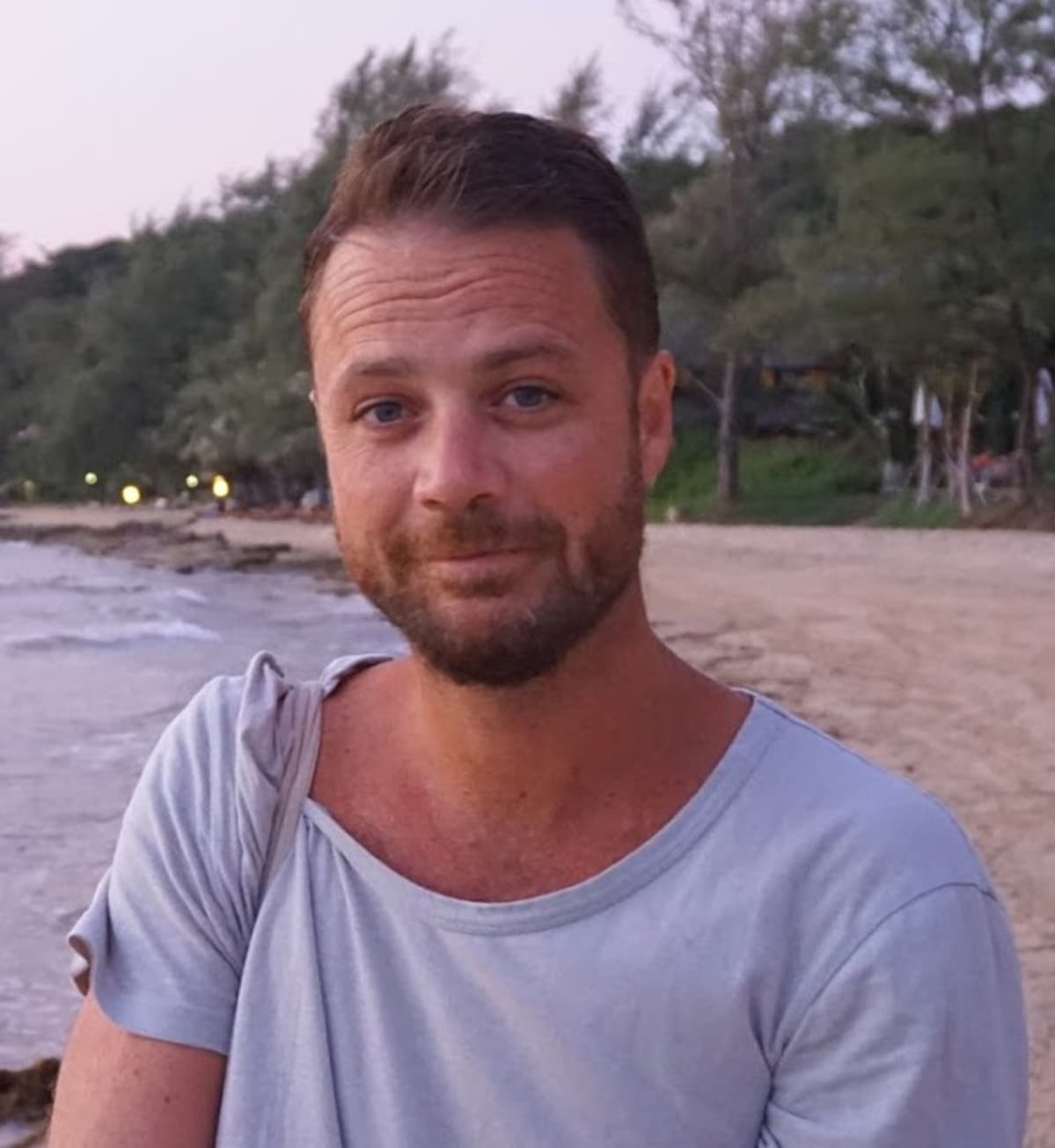 Uhri Chris Bevington katsoo kameraan rannalla.