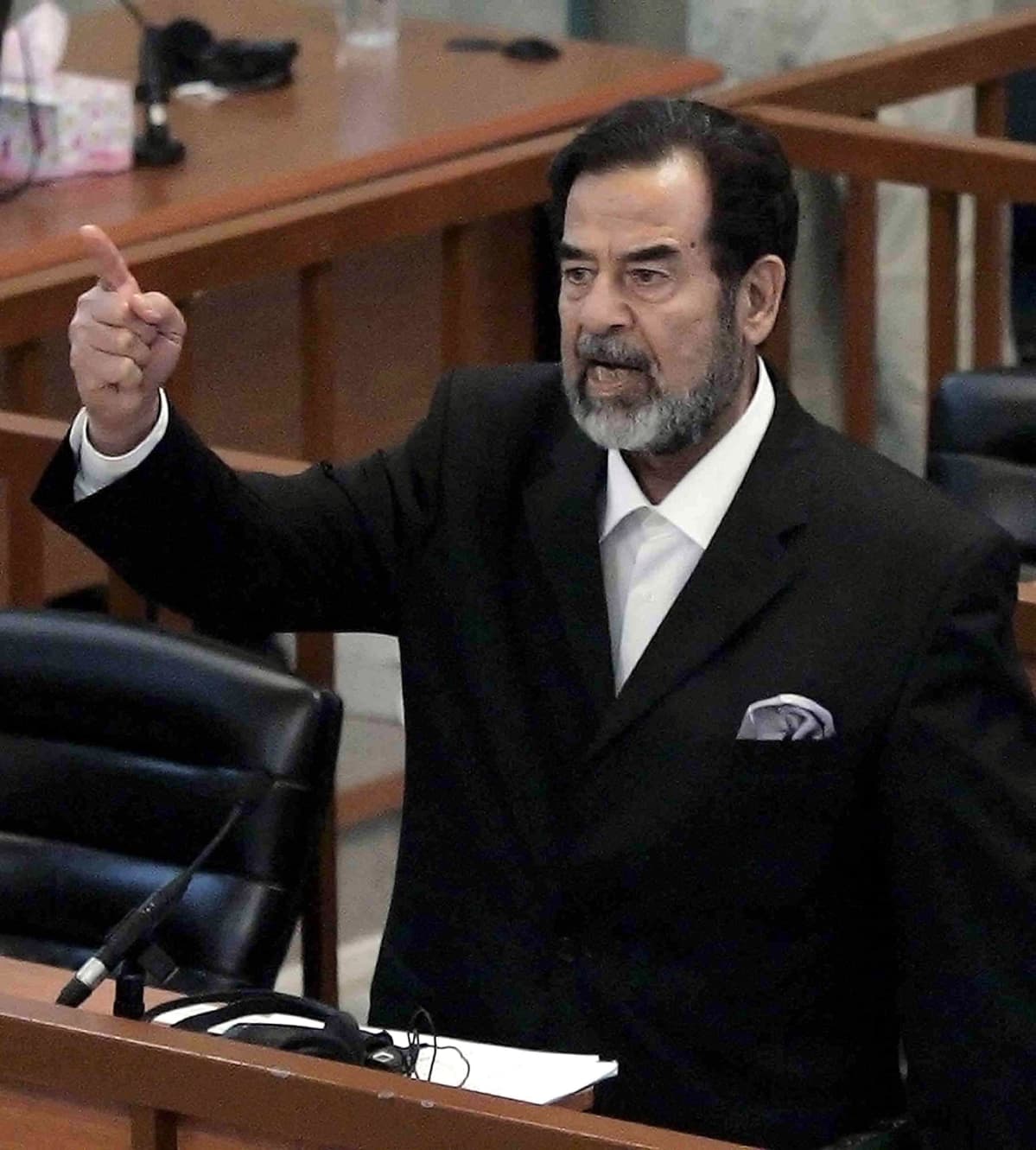 Saddam Hussein oikeudessa sormi pystyssä.
