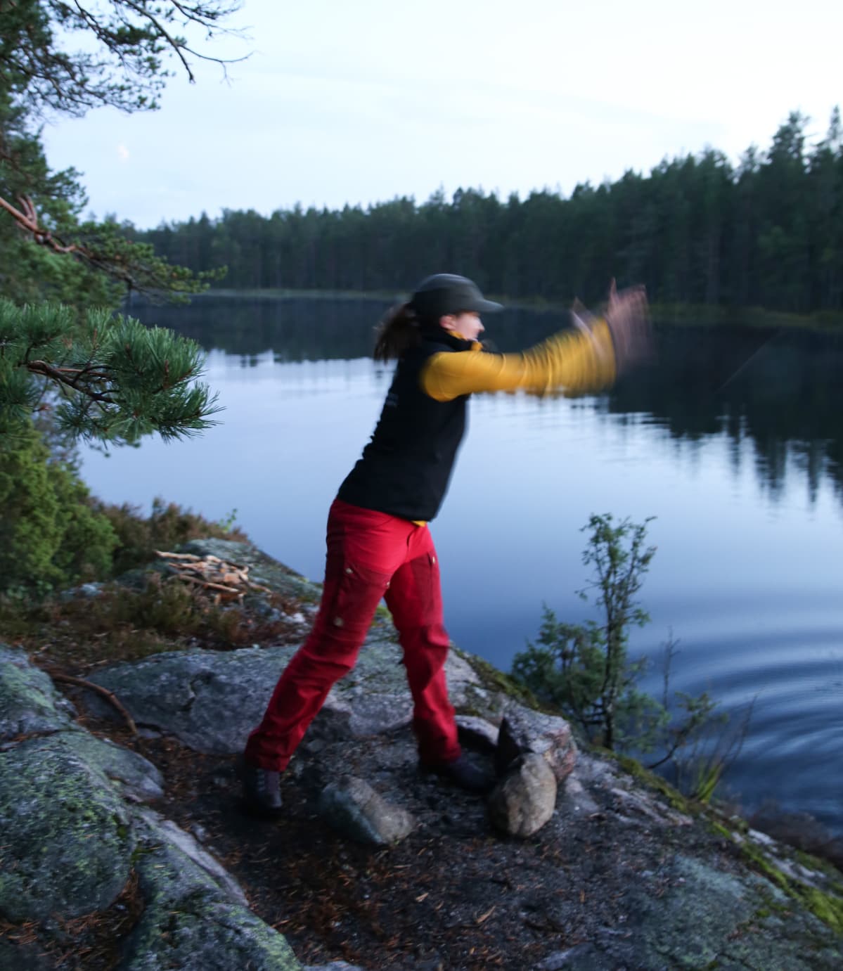 Loiskis. Metsähallituksen Liisa Neuvonen heittää laittoman nuotiopaikan kivet lampeen.