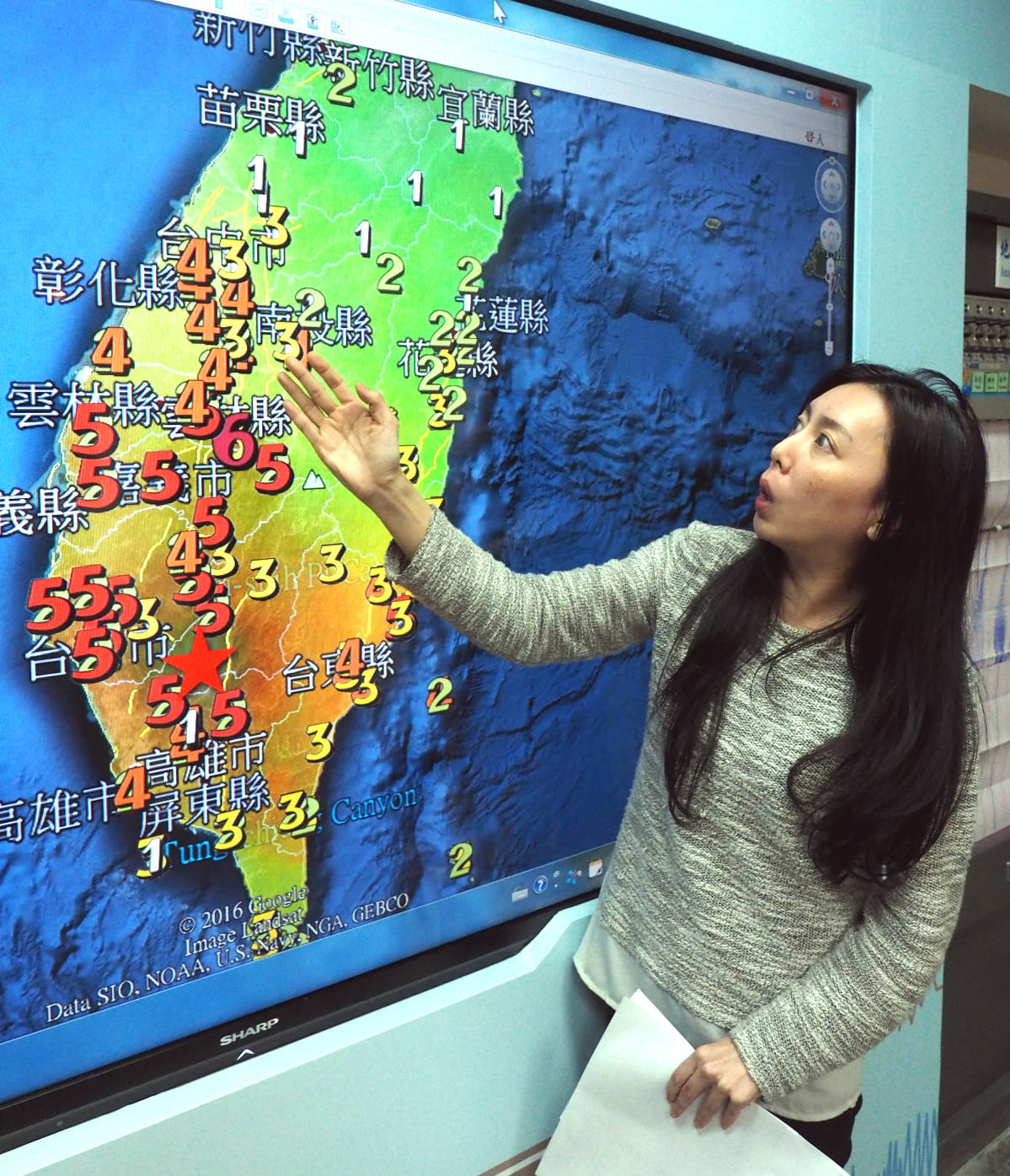 Seismologian keskuksen työntekijä esittelee maanjäristyksestä kertovaa karttaa Taiwanissa 6. helmikuuta 2016.