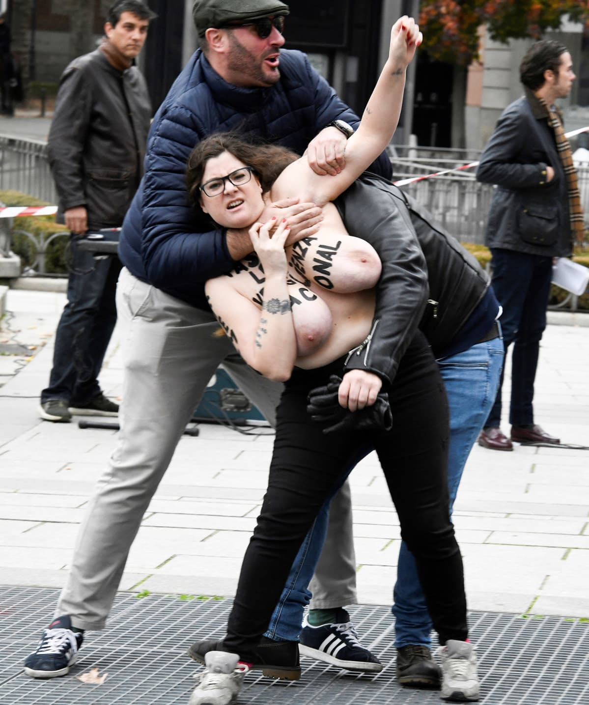 Kaksi miestä tarttui FEMEN-aktivistiin yrittääkseen pysäyttää hänet sen jälkeen, kun useat FEMEN-aktivistit häiritsivät Espanjan diktaattorin Francisco Francon kuoleman vuosipäivää pidettävää mielenosoitusta Oriente-aukiolla, Madridin keskustassa, Espanjassa, 18. marraskuuta. Espanjan hallitsija Francisco Franco kuoli 20. marraskuuta 1975.