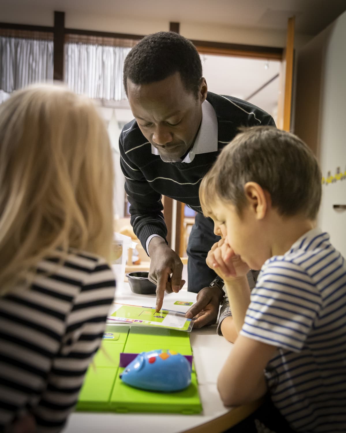 Malloy Nyakwama pelaa lasten kanssa koodauspeliä.