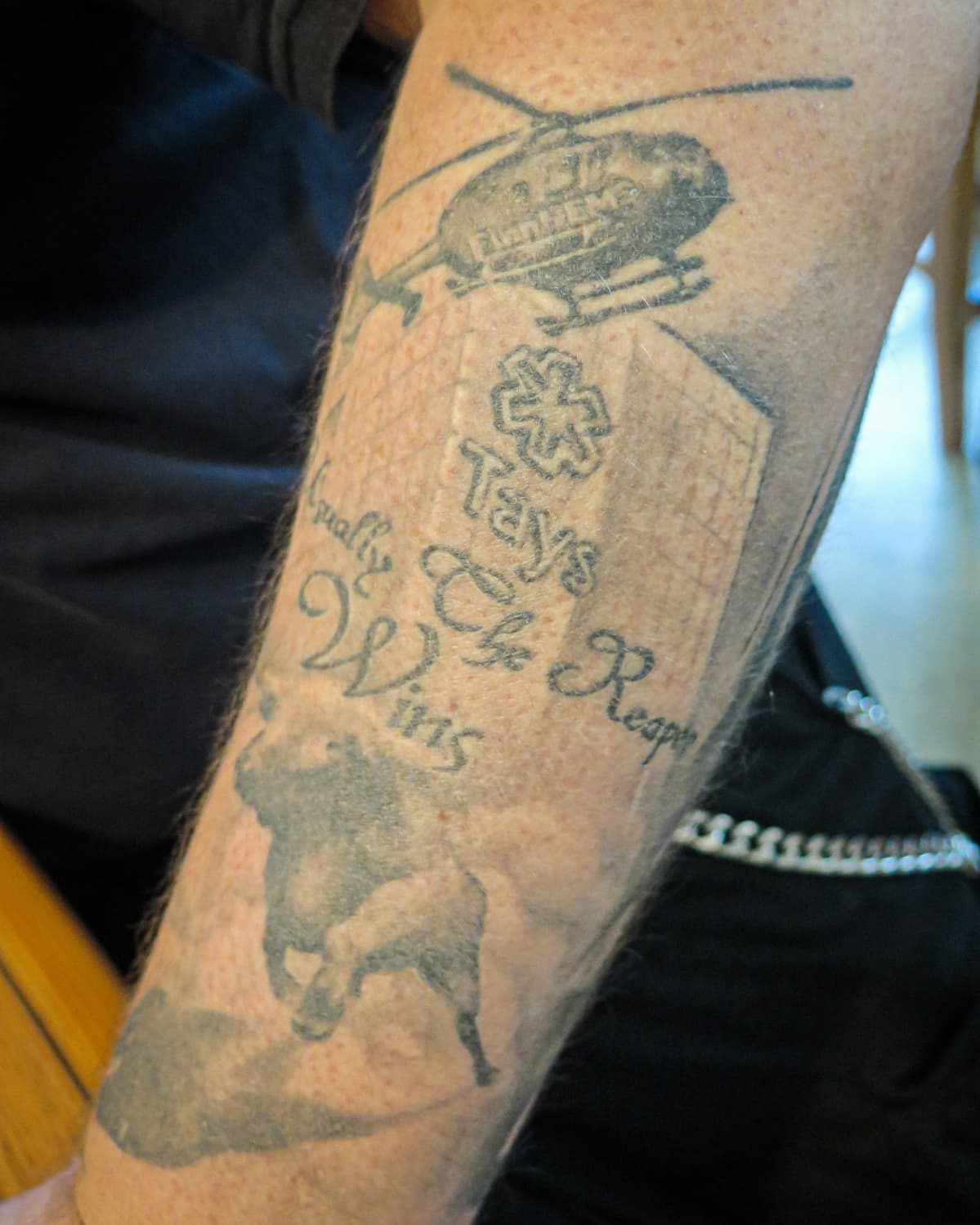 tatuoinnissa tays, lääkärihelikopteri ja juokseva sonni