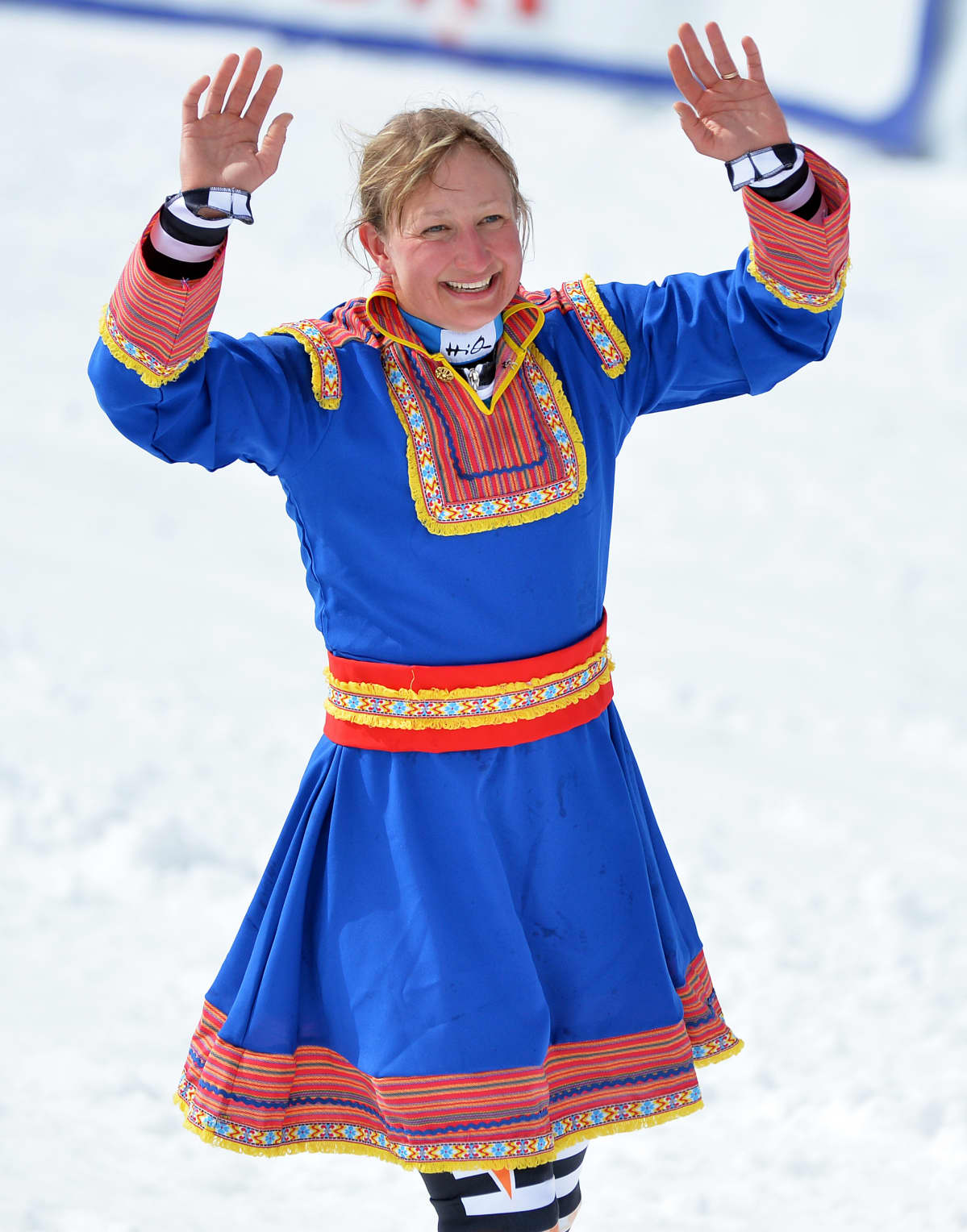 Tanja Poutiainen heiluttaa lapinpuvussa.