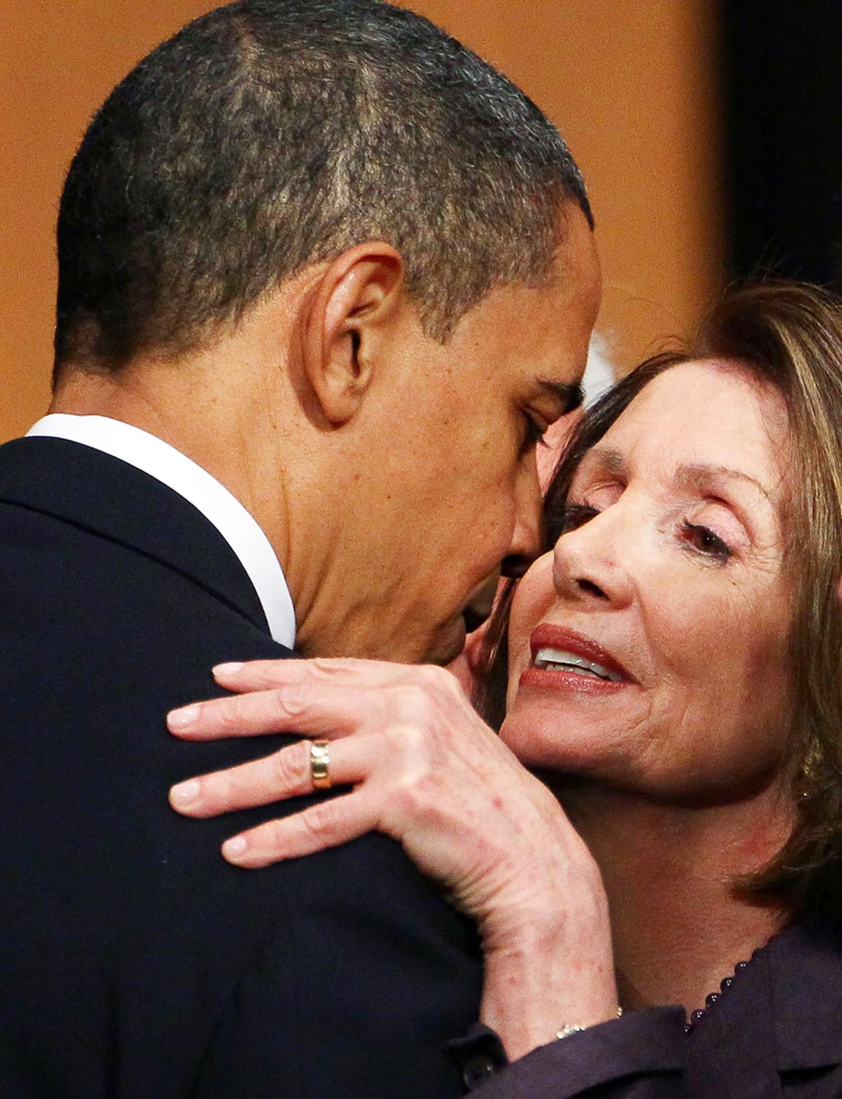 Lähikuva Nancy Pelosista halaamassa presidentti Barack Obamaa.