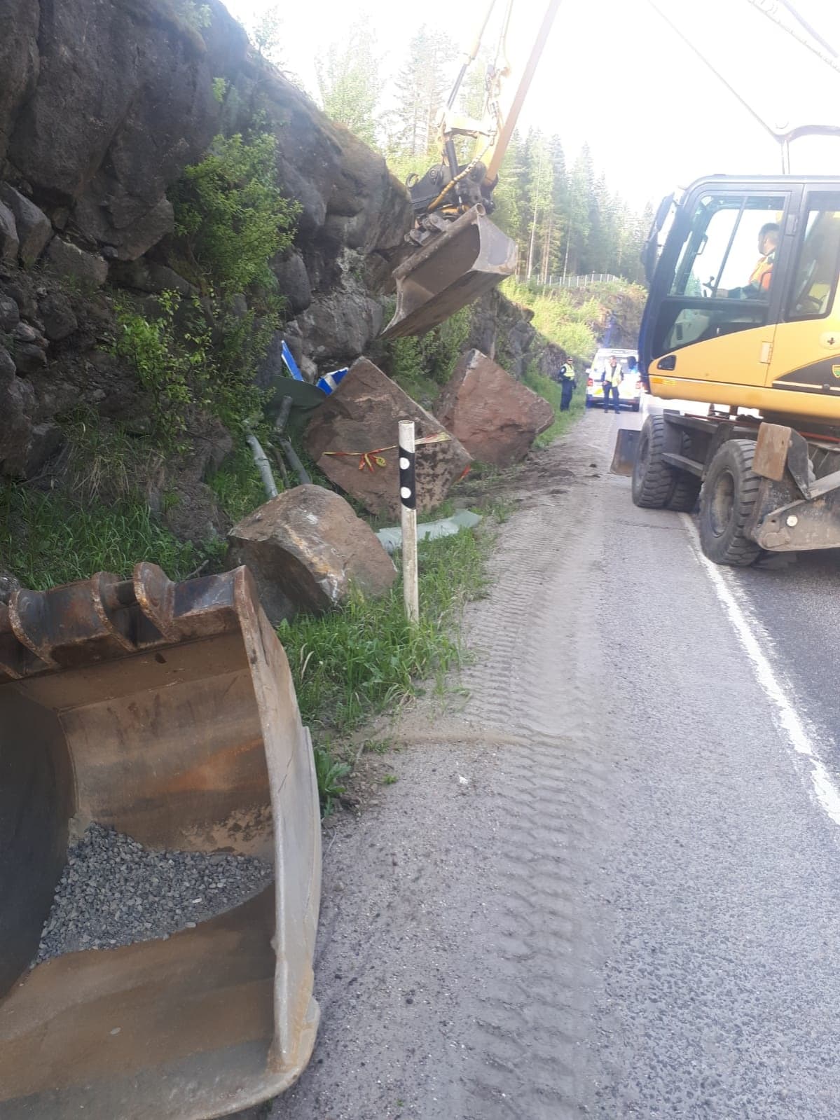 Kallioleikkauksesta irronneita kivenmurikoita siirretään kaivinkoneella.