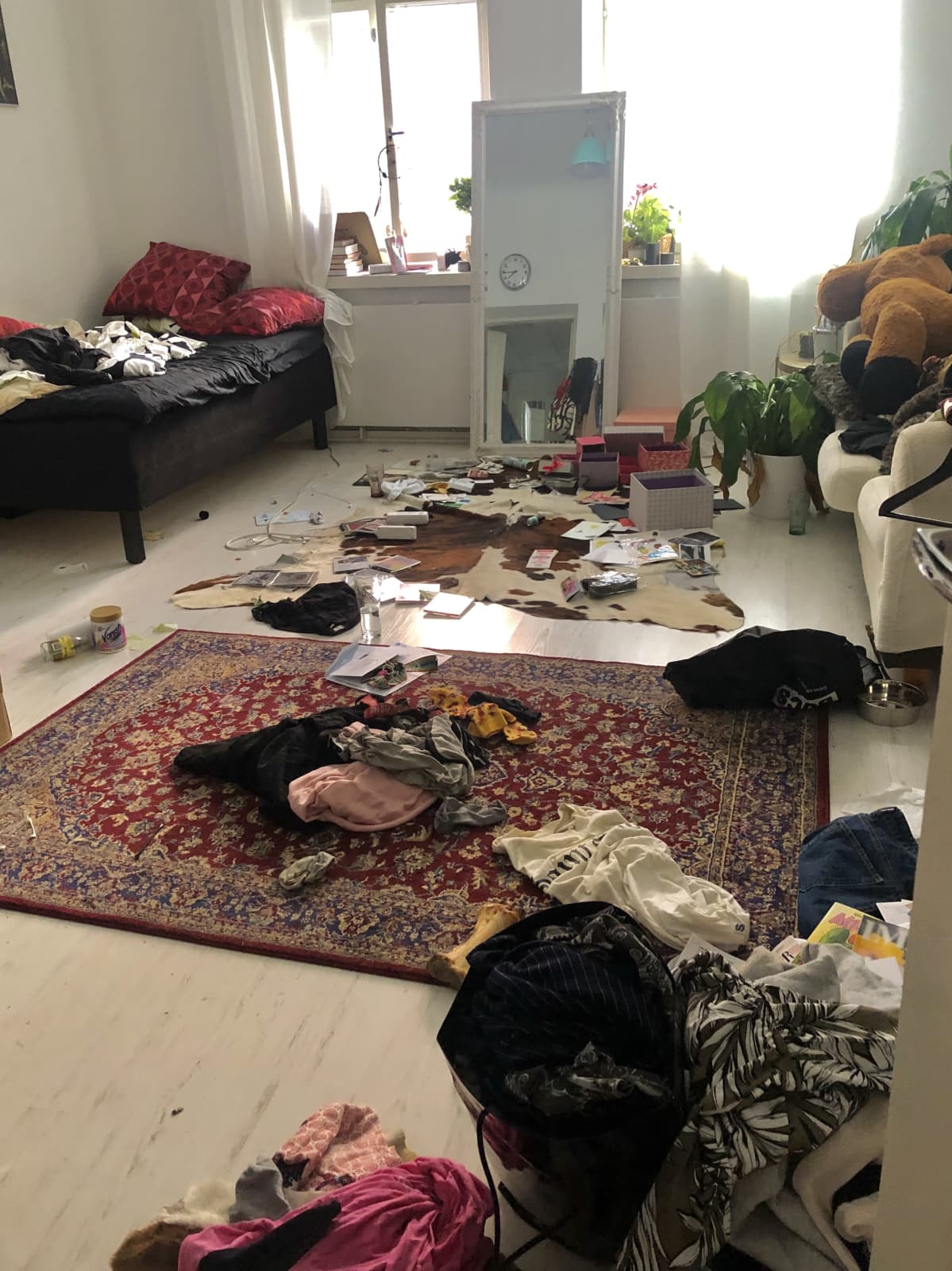 Huone jossa tavaraa ympäri lattiaa.