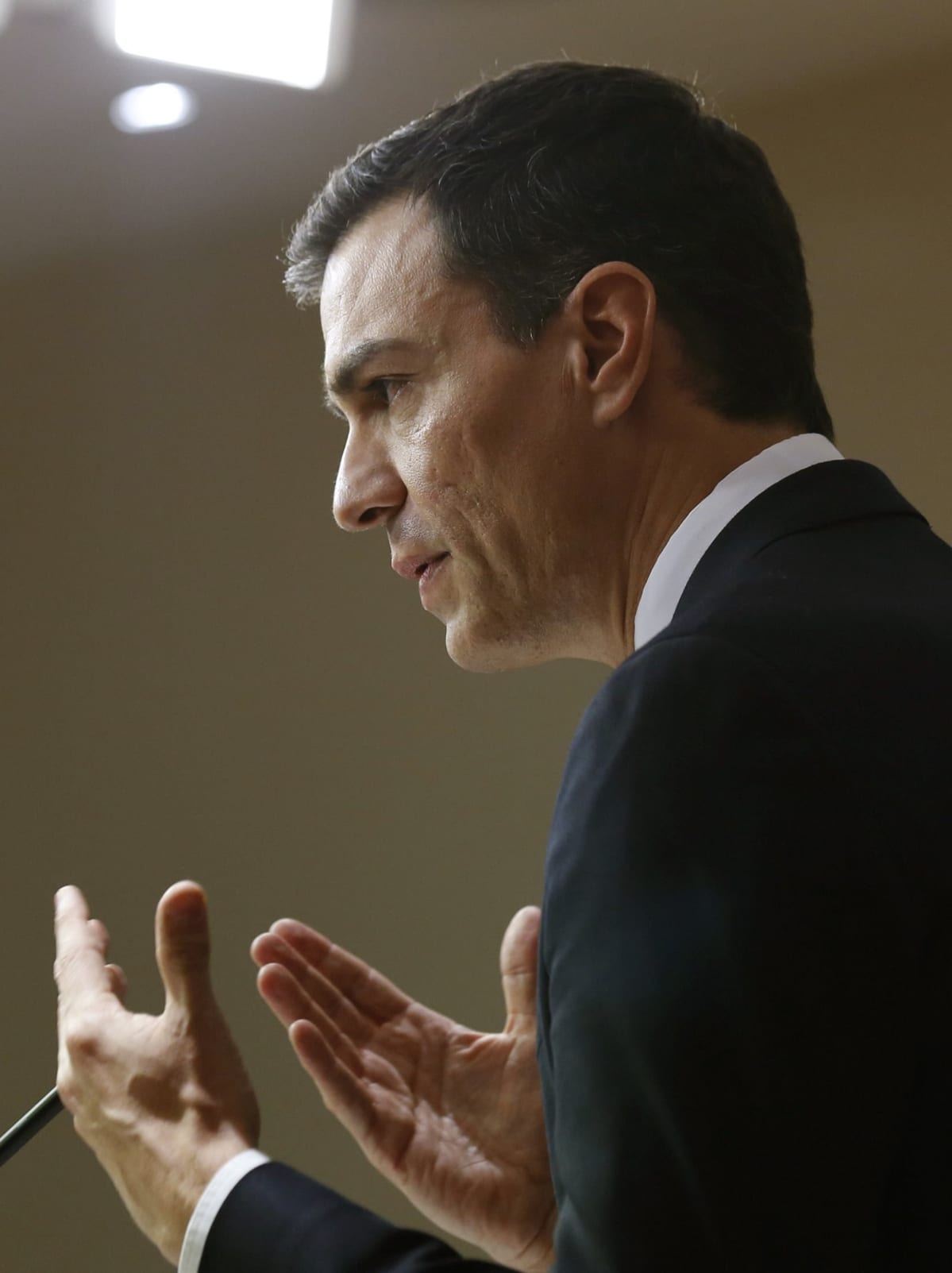 Espanjan sosialistijohtaja Pedro Sánchez puhuu medialle Espanjan parlamentin alahuoneessa Madridissa. Sánchezilla on musta puku. Hänen edessään näkyy mikrofoni. Sánchez näyttää vakavalta ja korostaa sanojaan molemmilla käsillään.
