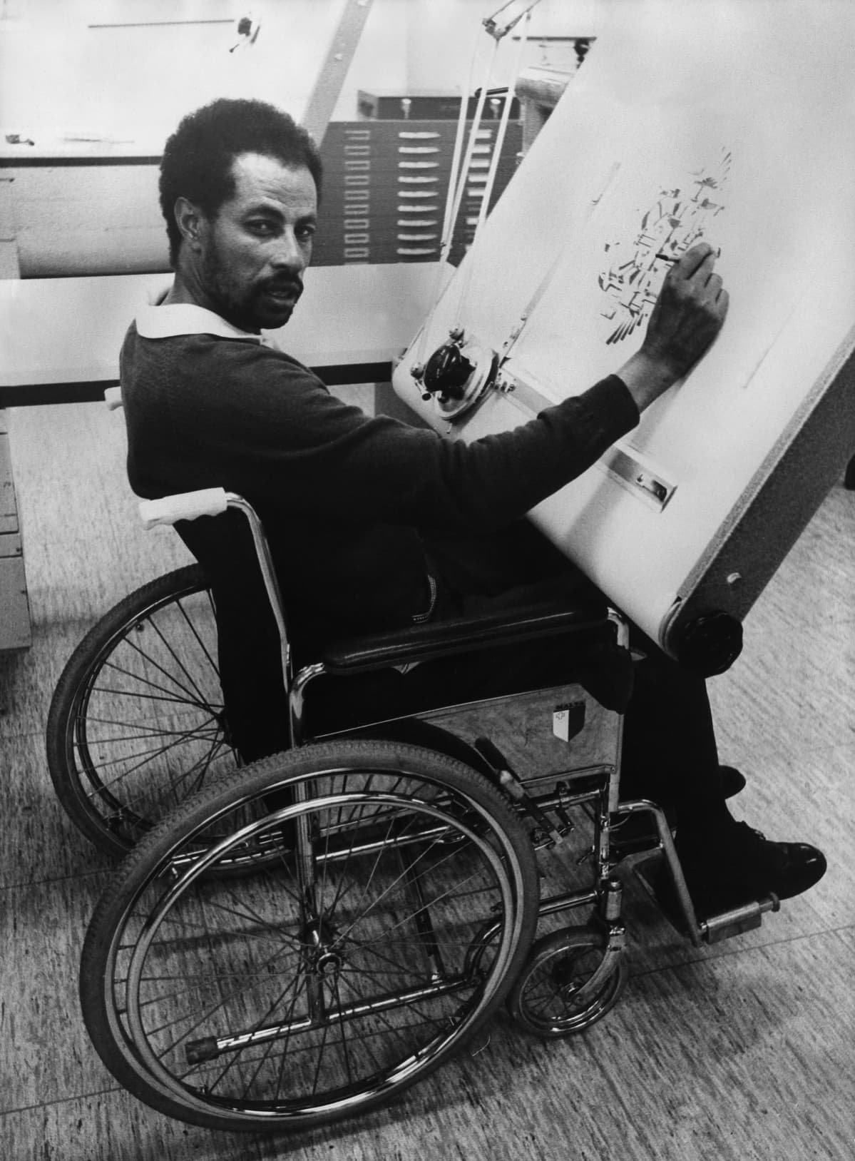 Abebe Bikila, juoksija pyörätuolissa piirustuspöydän ääressä