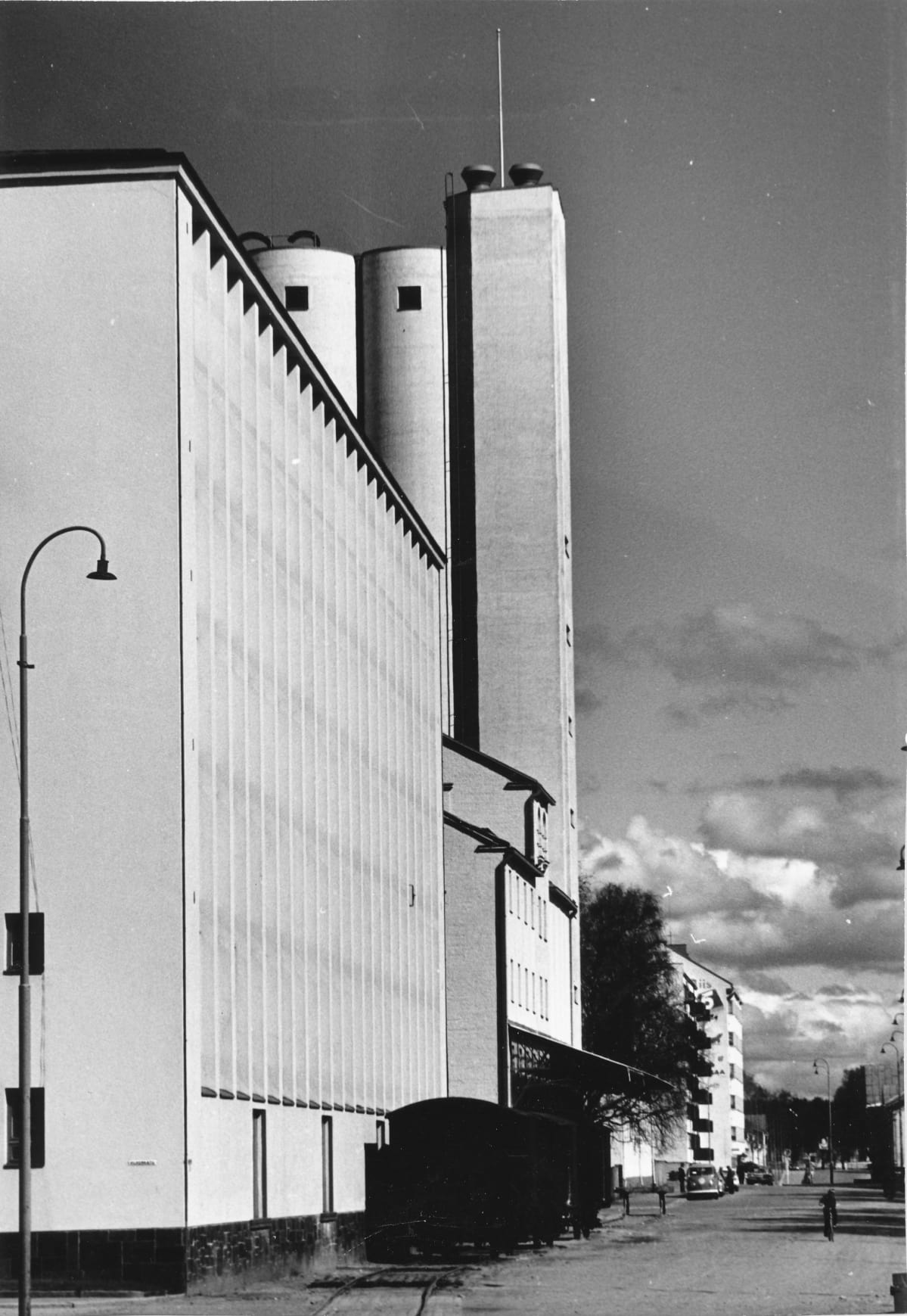 Näkymä Mannerheimintieltä 1960-1970-luvulta. Etualalla vasemmalla on SOK:n konttori- ja varastorakennus, jonka vieressä valssimylly. taustalla kohoavat viljasiilot.