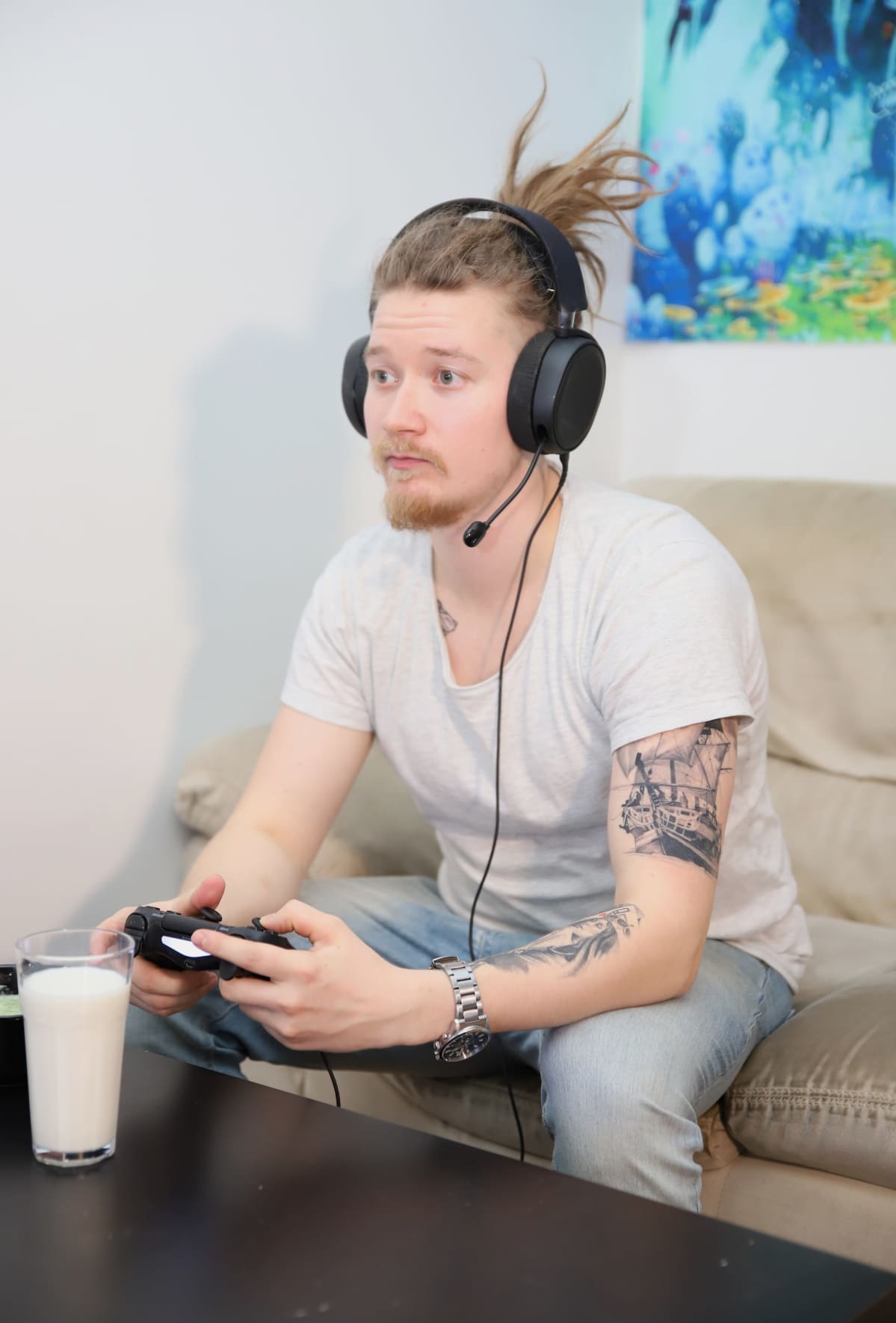 Janne Lahtinen pelaa videopeliä kuulokkeet päässään kotonaan.