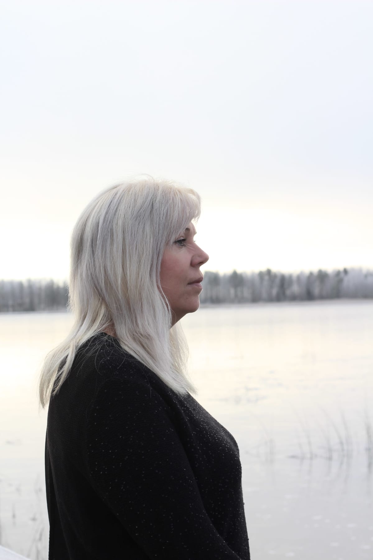 Natalia Alaspää katselee jäätyneelle Räyringinjärvelle.