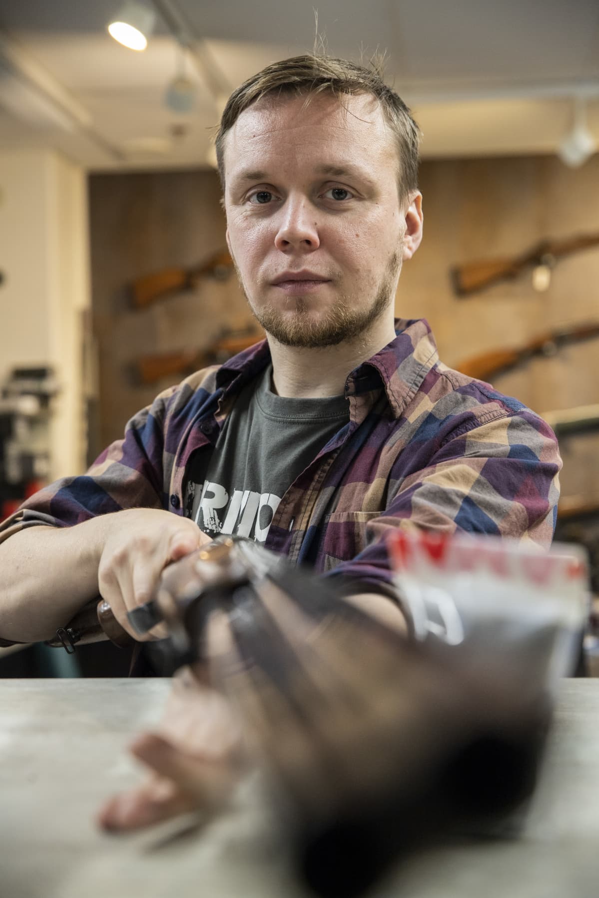 Armoria ase-liikkeen yrittäjä Vesa-Matti Iskanius käsittelee haulikkoa liikkeessään.