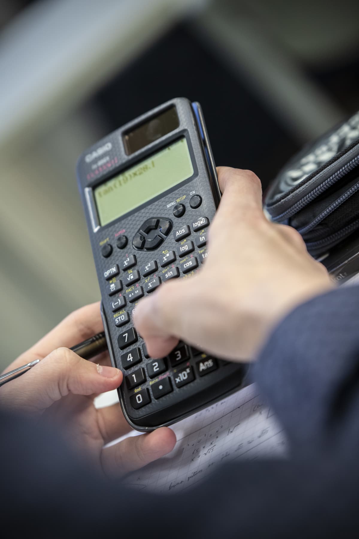 Opiskelija laskee matematiikkaa laskimella