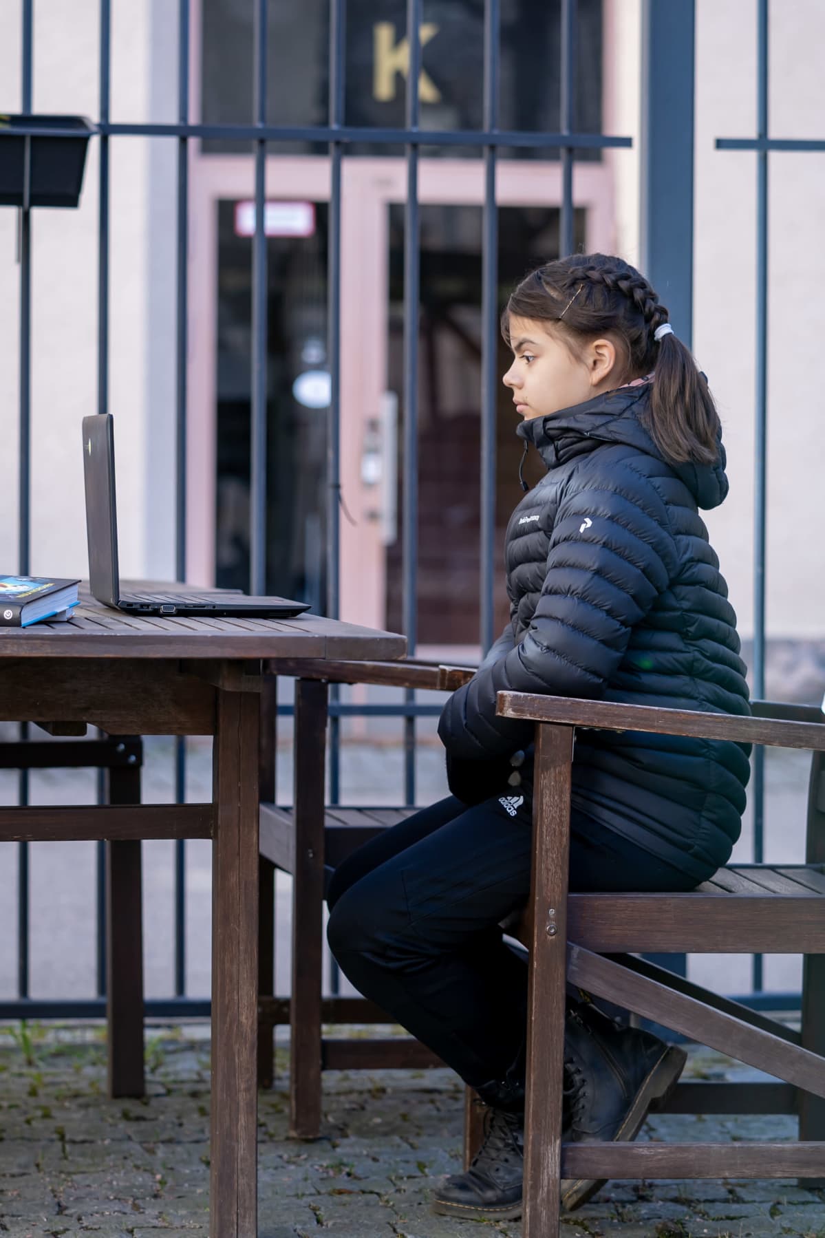 Koululainen Linnea Rimminen seuraamassa kirjailija Paula Norosen virtuaalivierailua kotinsa sisäpihalla, Vallila, Helsinki, 8.4.2020.