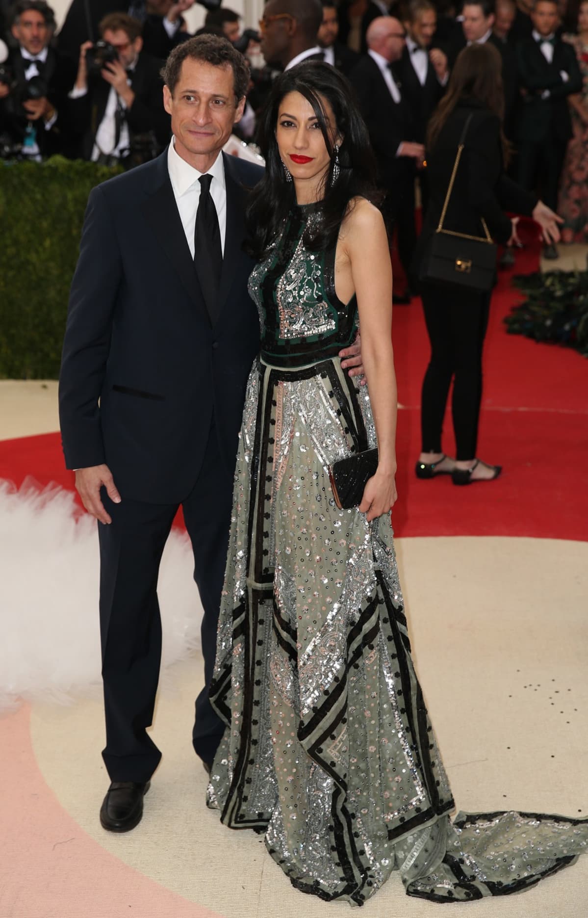 Huma Abedin kimaltavassa iltapuvussa, vierellä tummaan pukuun pukeutunut Anthony Weiner.