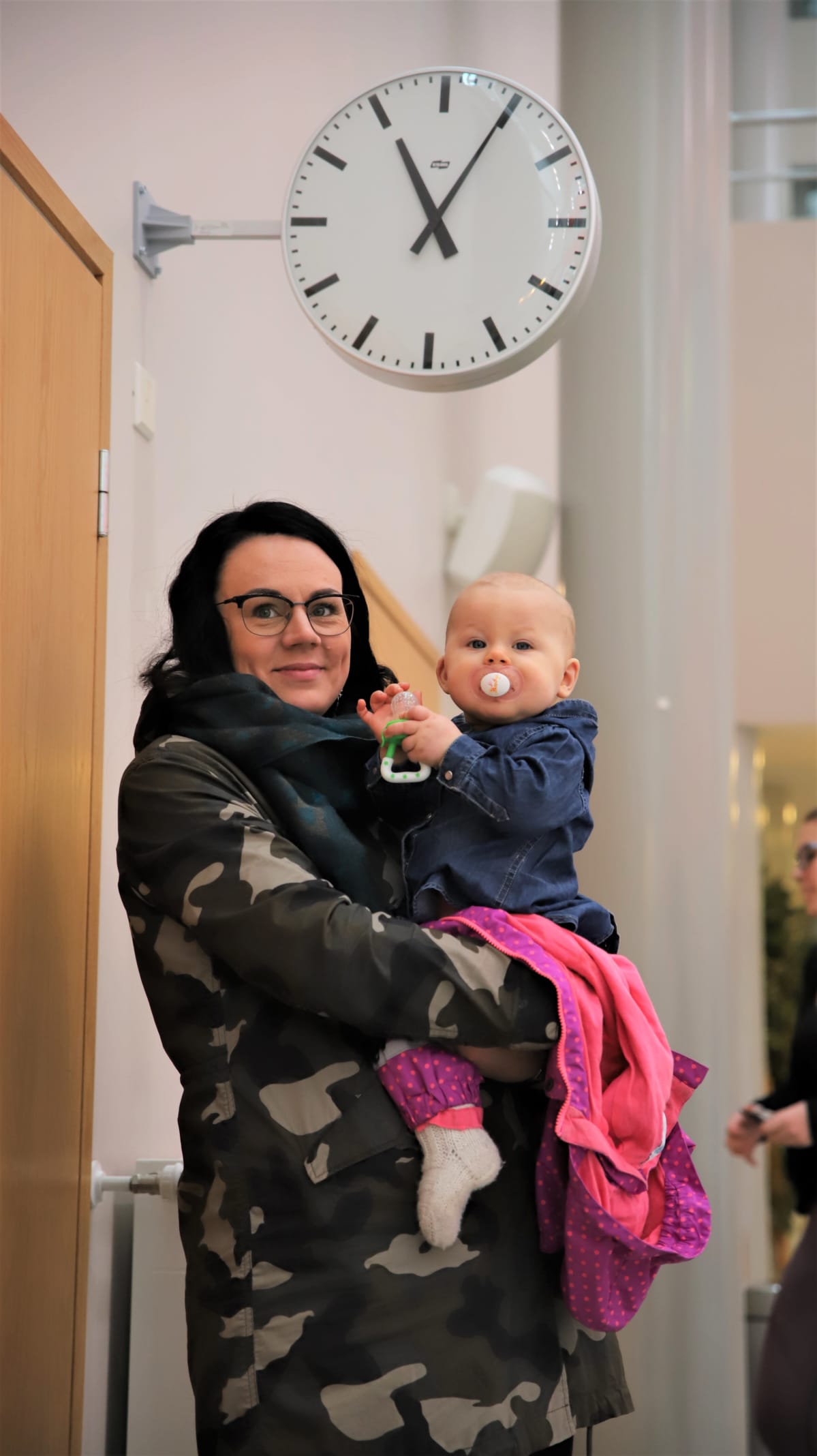 Hanna Ylitarvas ja lapsi koulun kellon alla