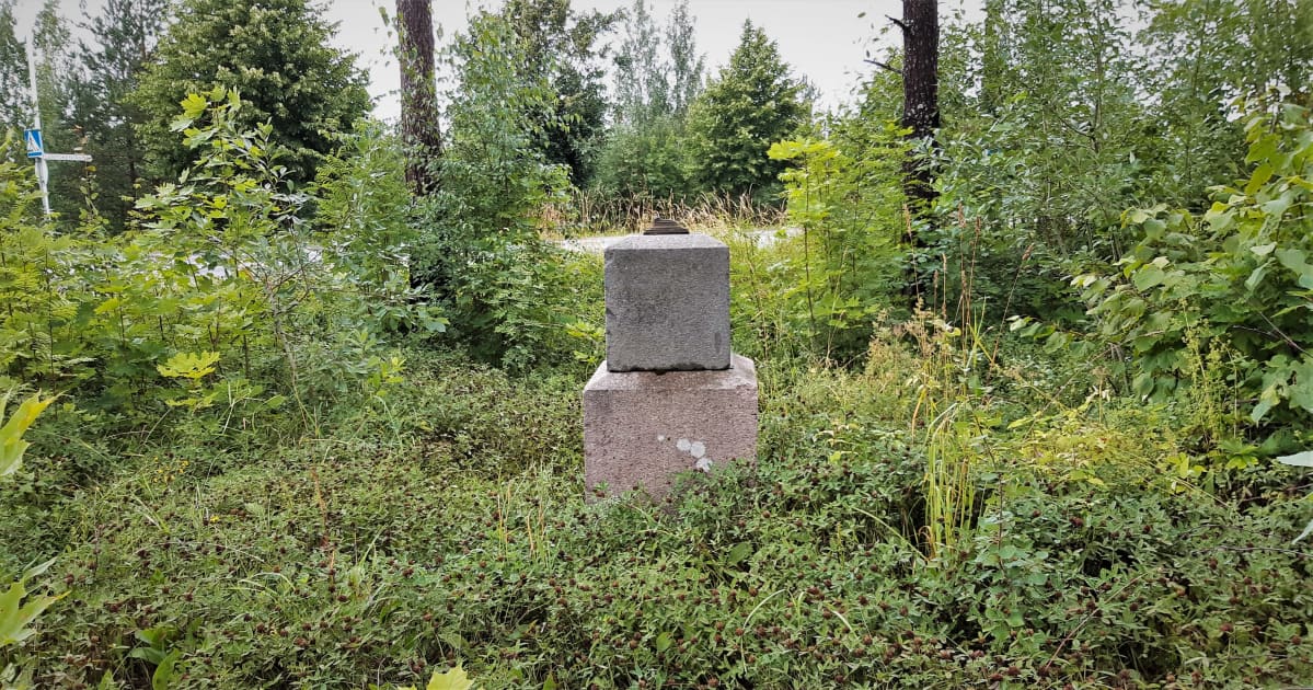 Alkuperäisen leirikirkon muistokivi pusikon keskellä