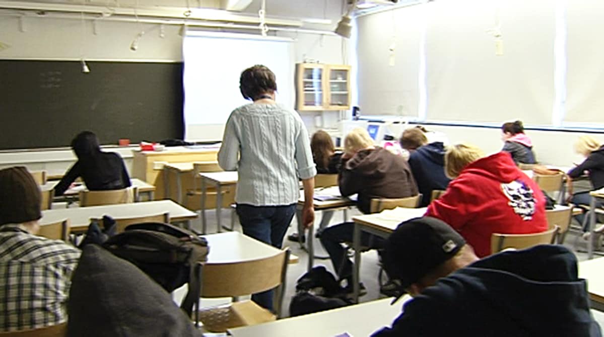 Opettaja kävelee luokassa.
