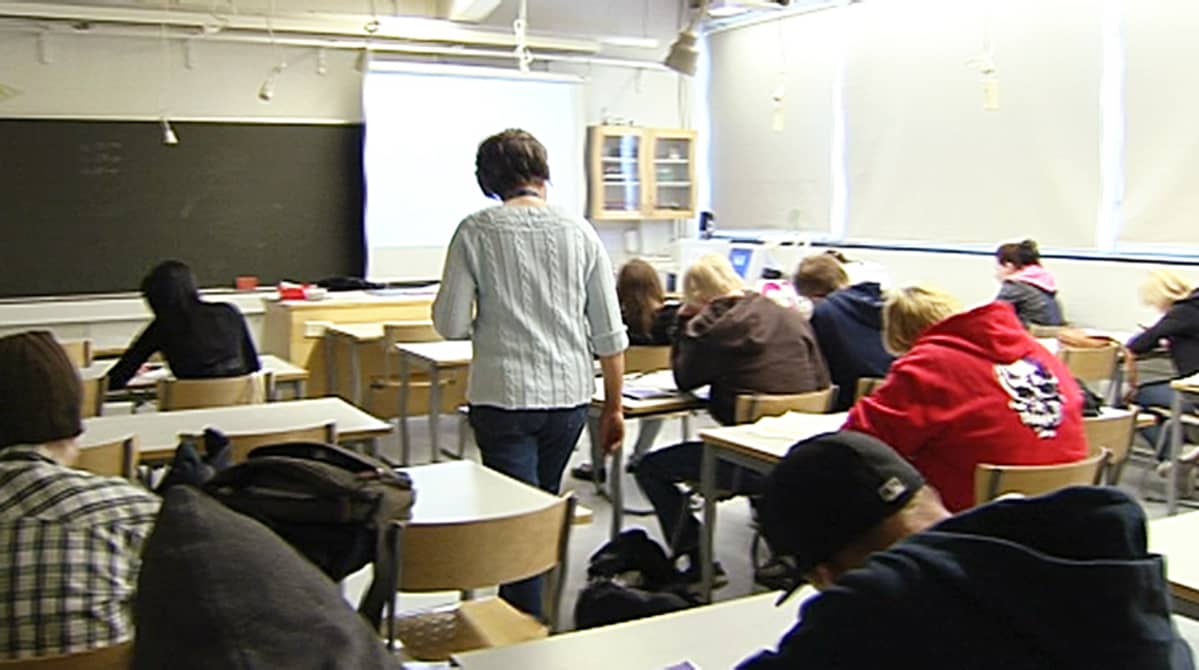 Opettaja kävelee luokassa.