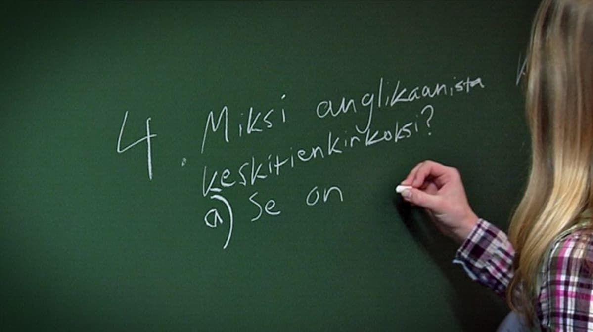 Oppilas kirjoittaa liitutaululle Kulosaaren yhteiskoulussa.
