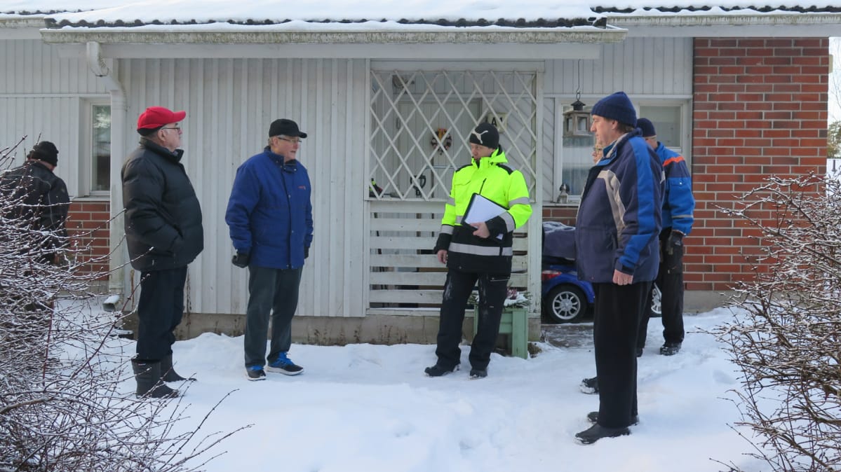 Asukkaat ja rakennustarkastaja rivitalon pihalla