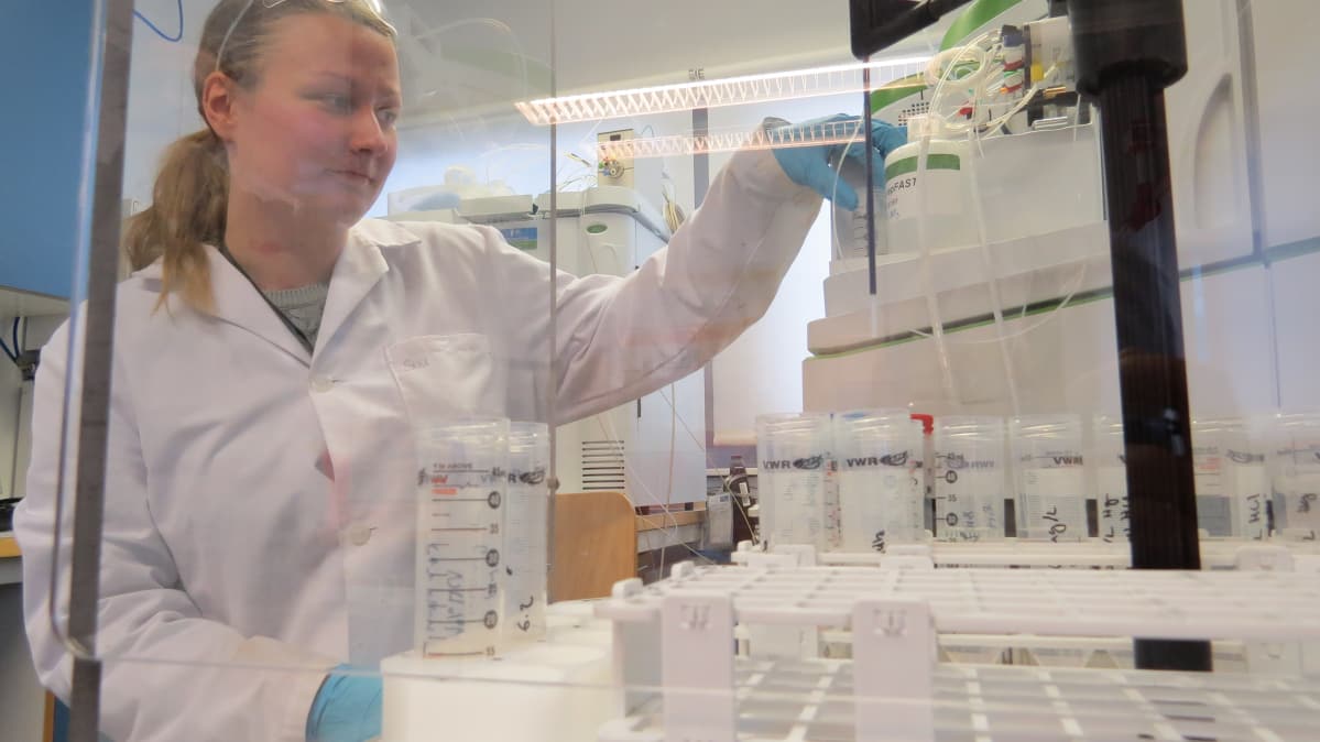 Tutkija tarkastelee mittauslaitetta laboratoriossa
