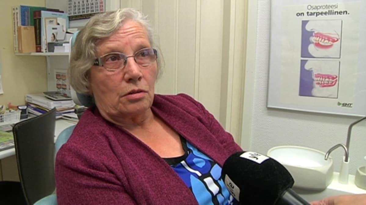 nainen istuu hammaslääkärin tuolissa